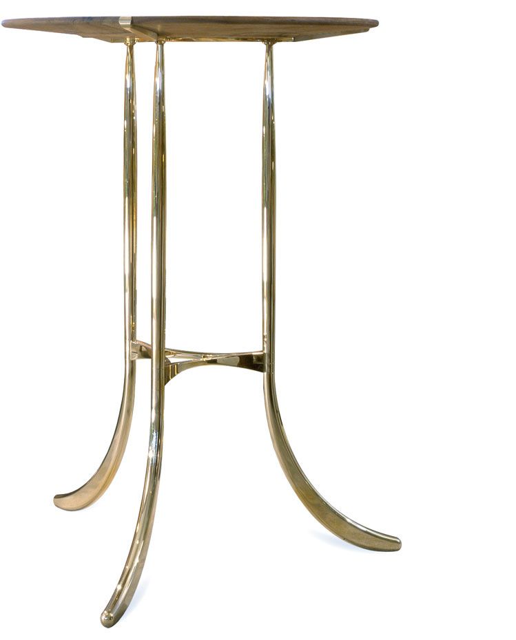 a small brass table with a wooden top on a white background .