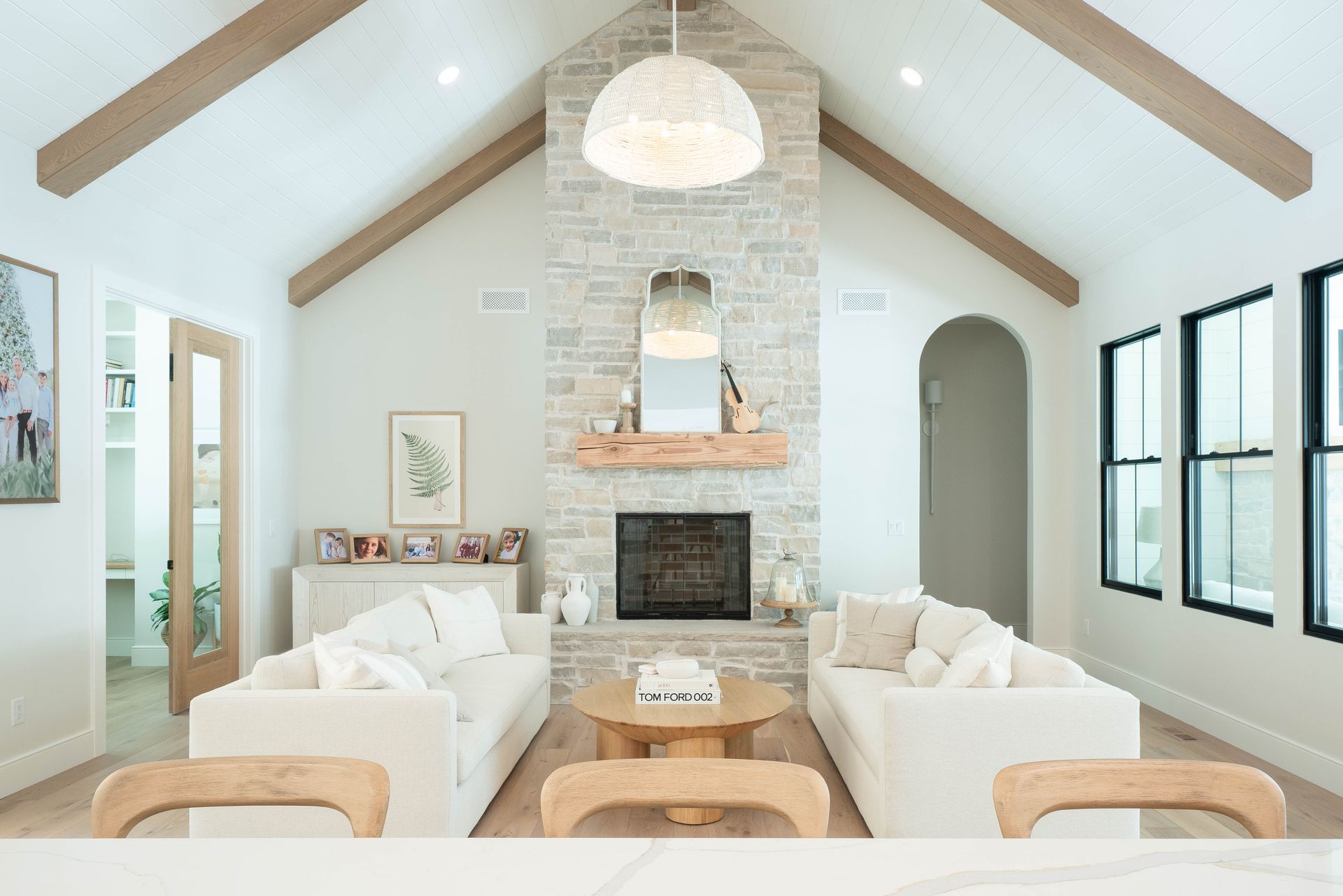 A living room with two couches , a fireplace , and a vaulted ceiling.