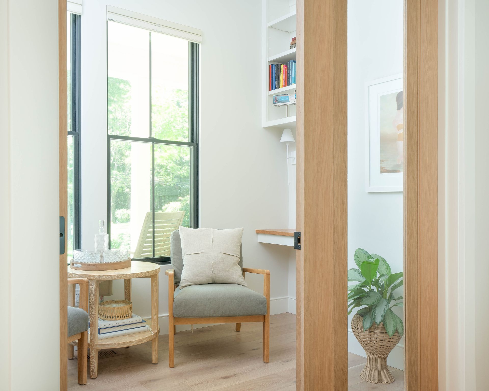 A living room with a chair , table and window.