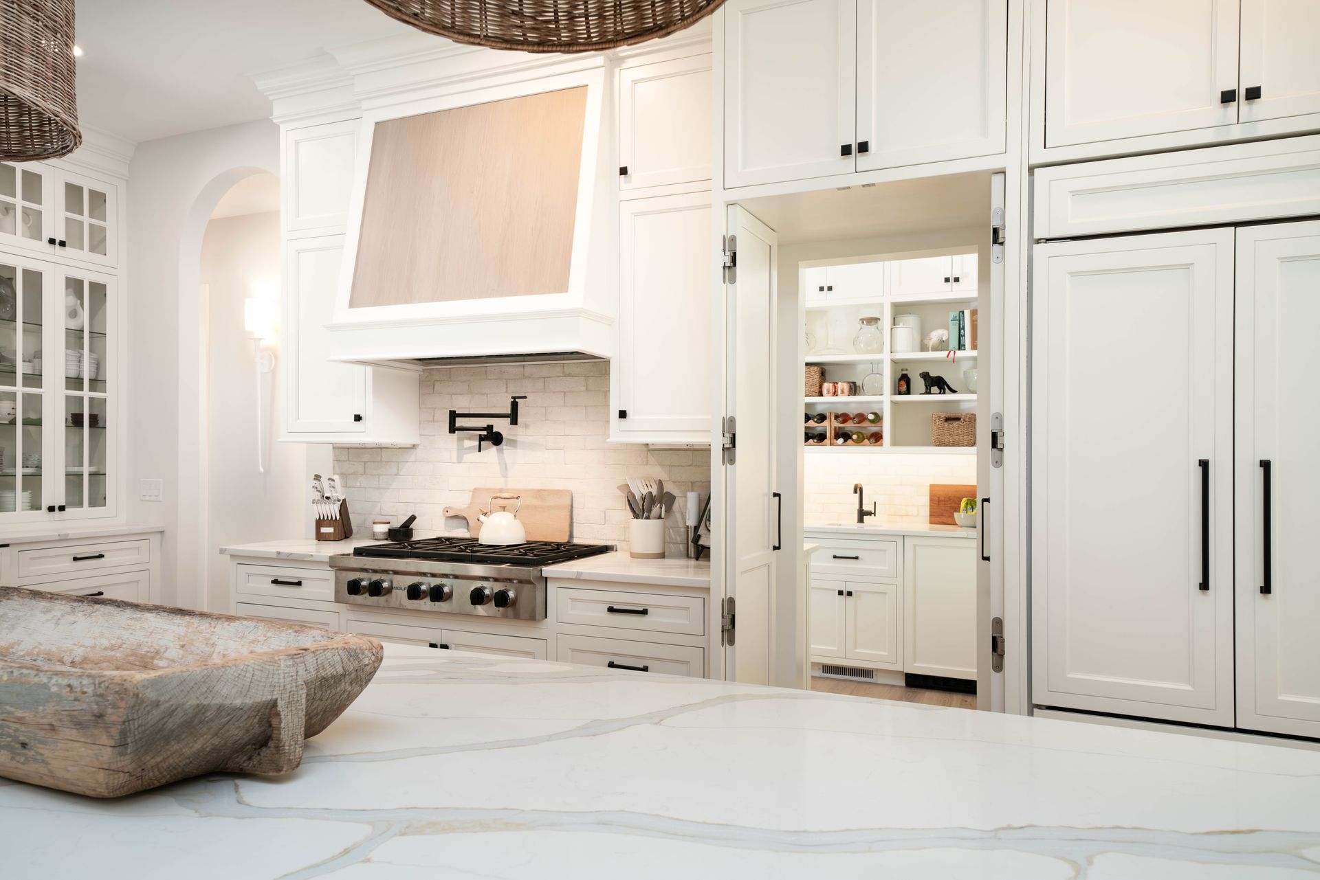 A kitchen with white cabinets , granite counter tops , stainless steel appliances , and a large island.