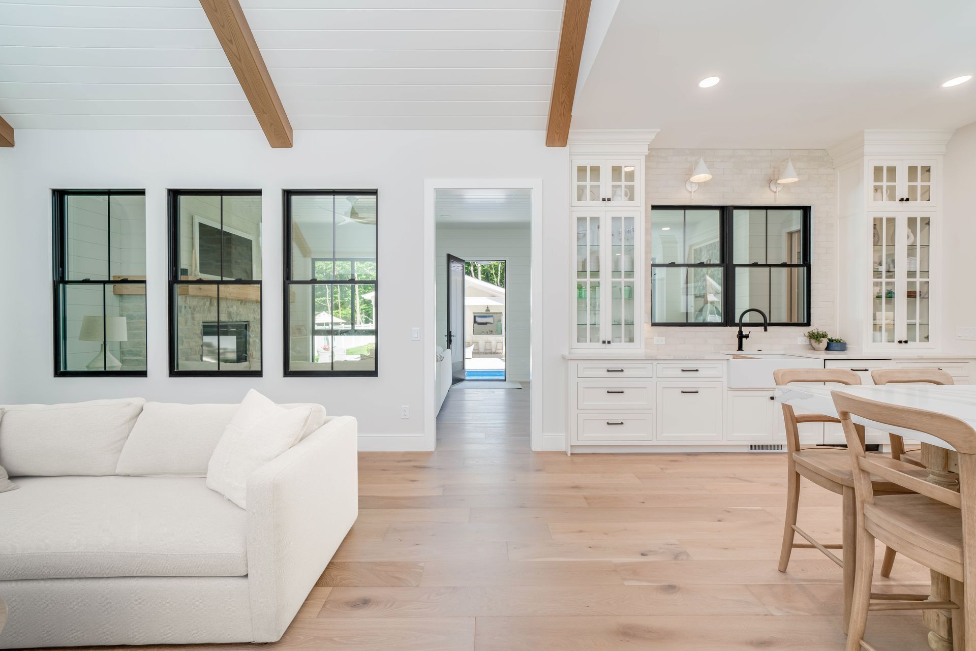A living room with a white couch , dining table and chairs.