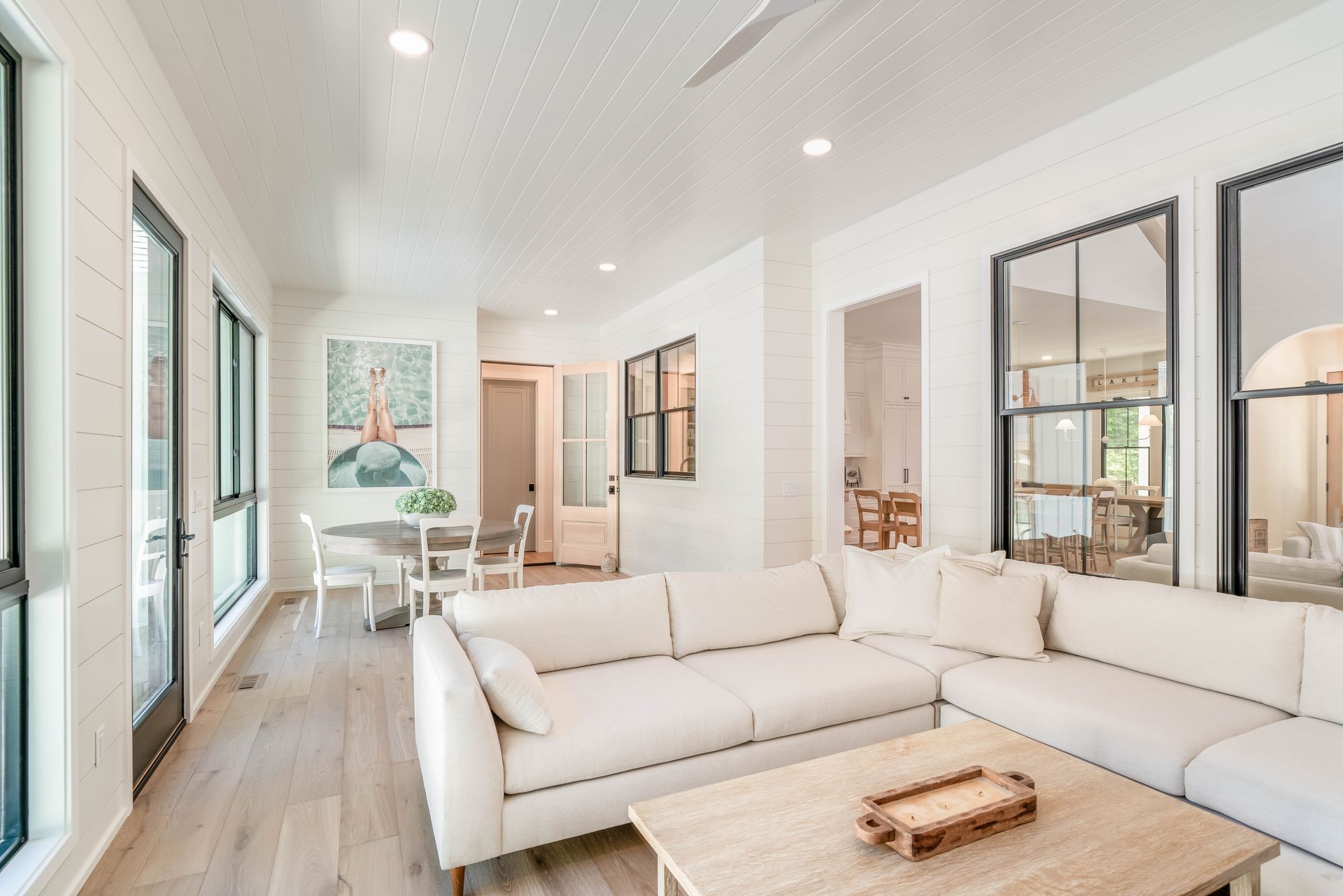 A living room with a white sectional couch and a wooden coffee table.