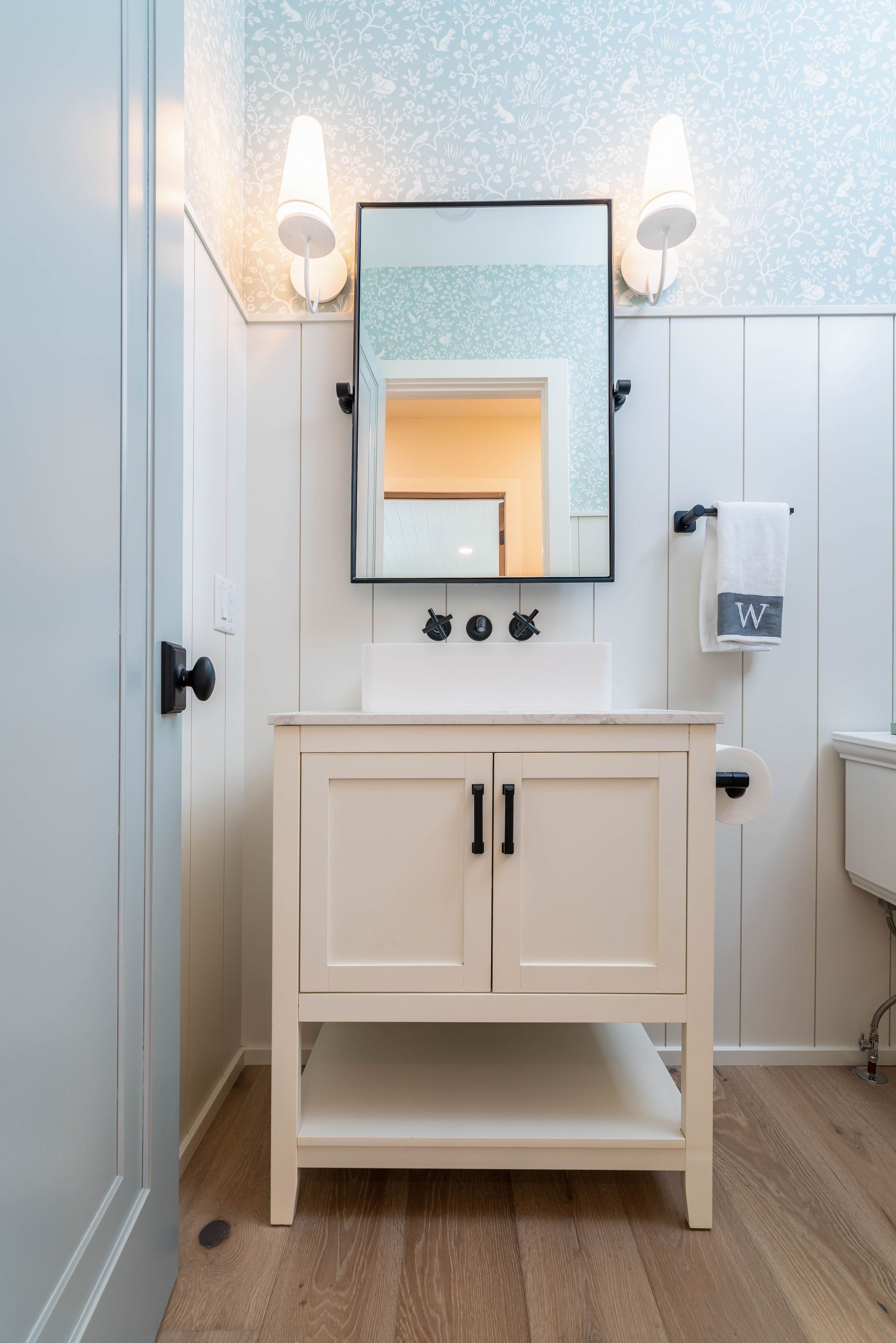 A bathroom with a sink , mirror and toilet.