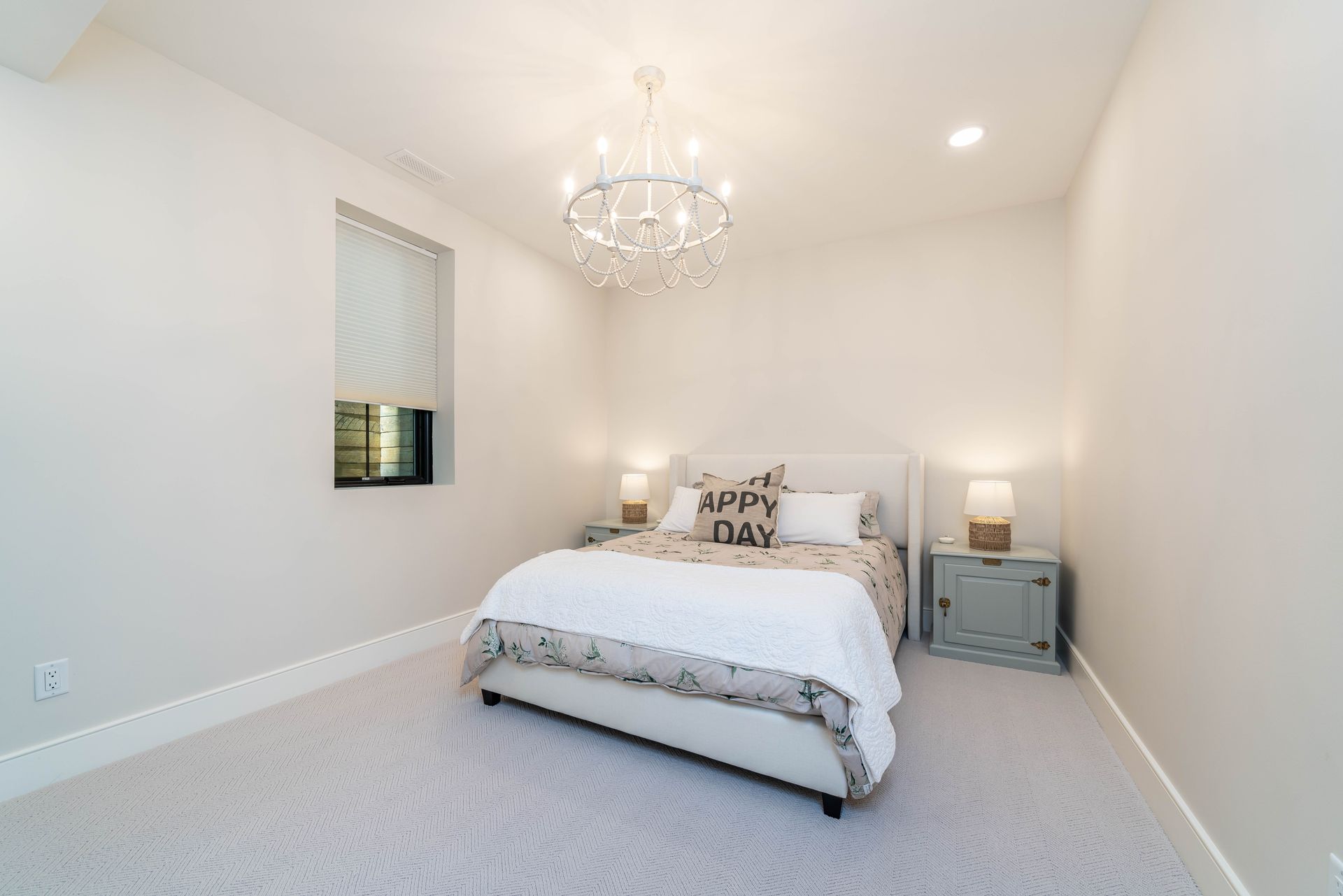 A bedroom with a bed , nightstand , and chandelier.