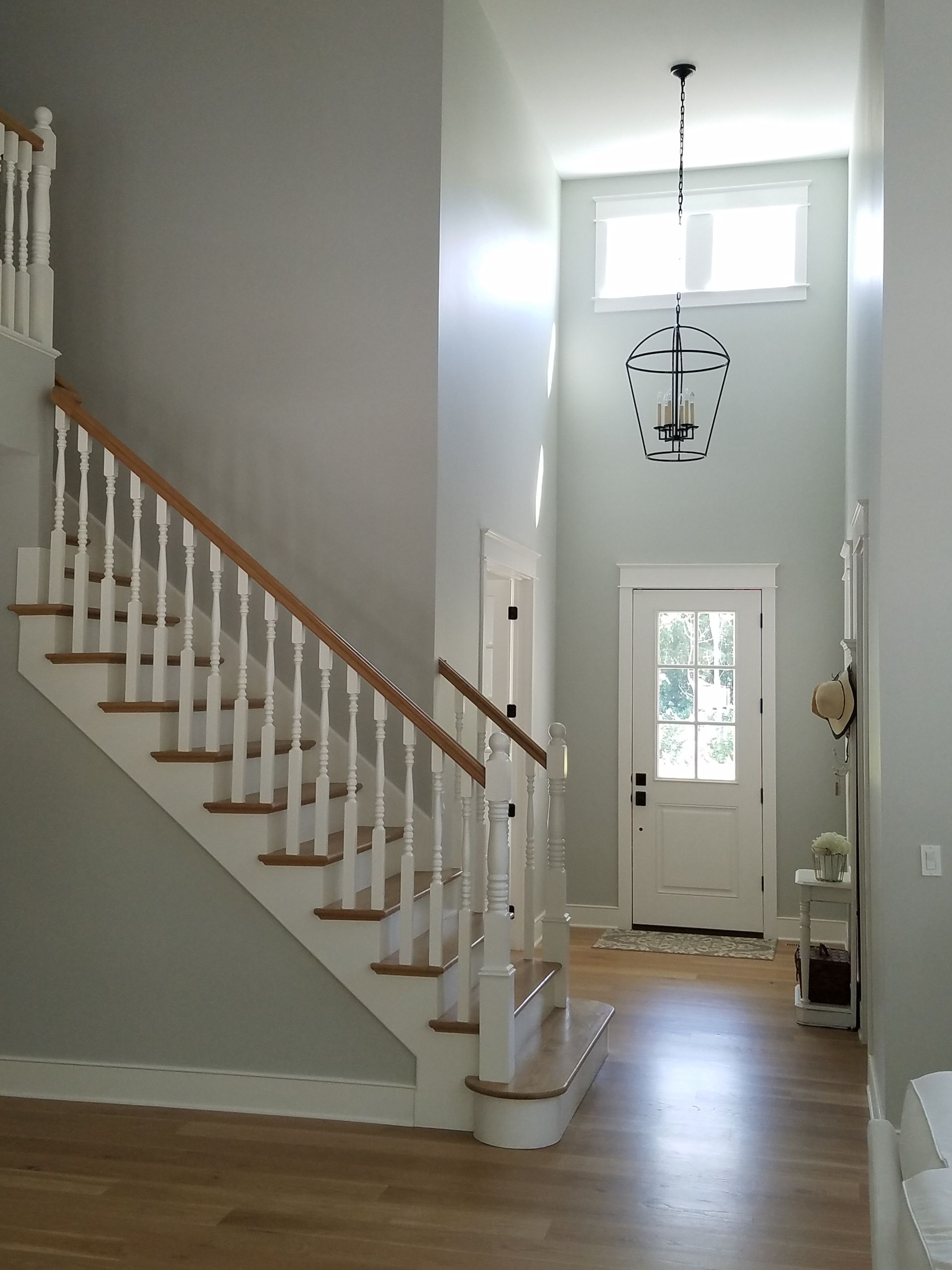 A staircase in a house with a chandelier hanging from the ceiling