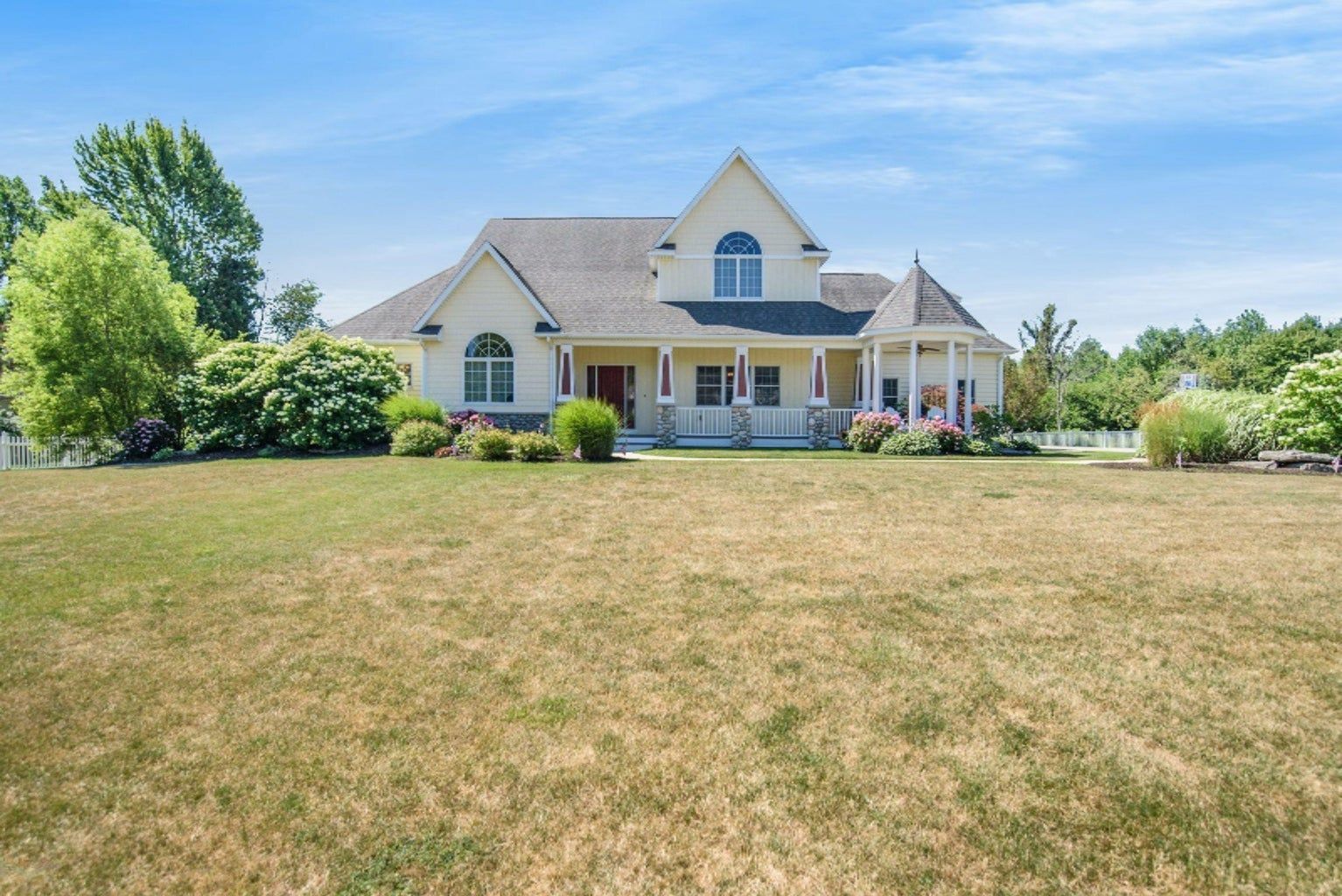 A large white house with a large lawn in front of it