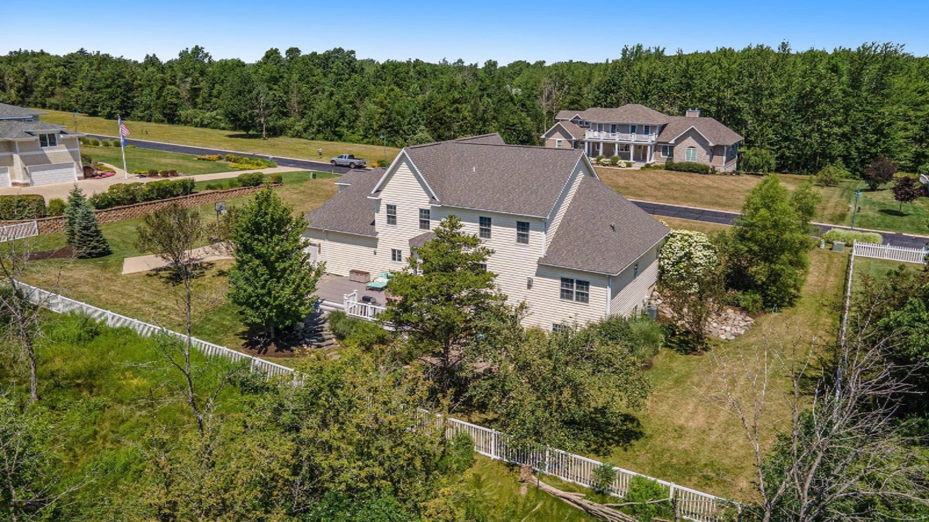 An aerial view of a large house surrounded by trees and grass.