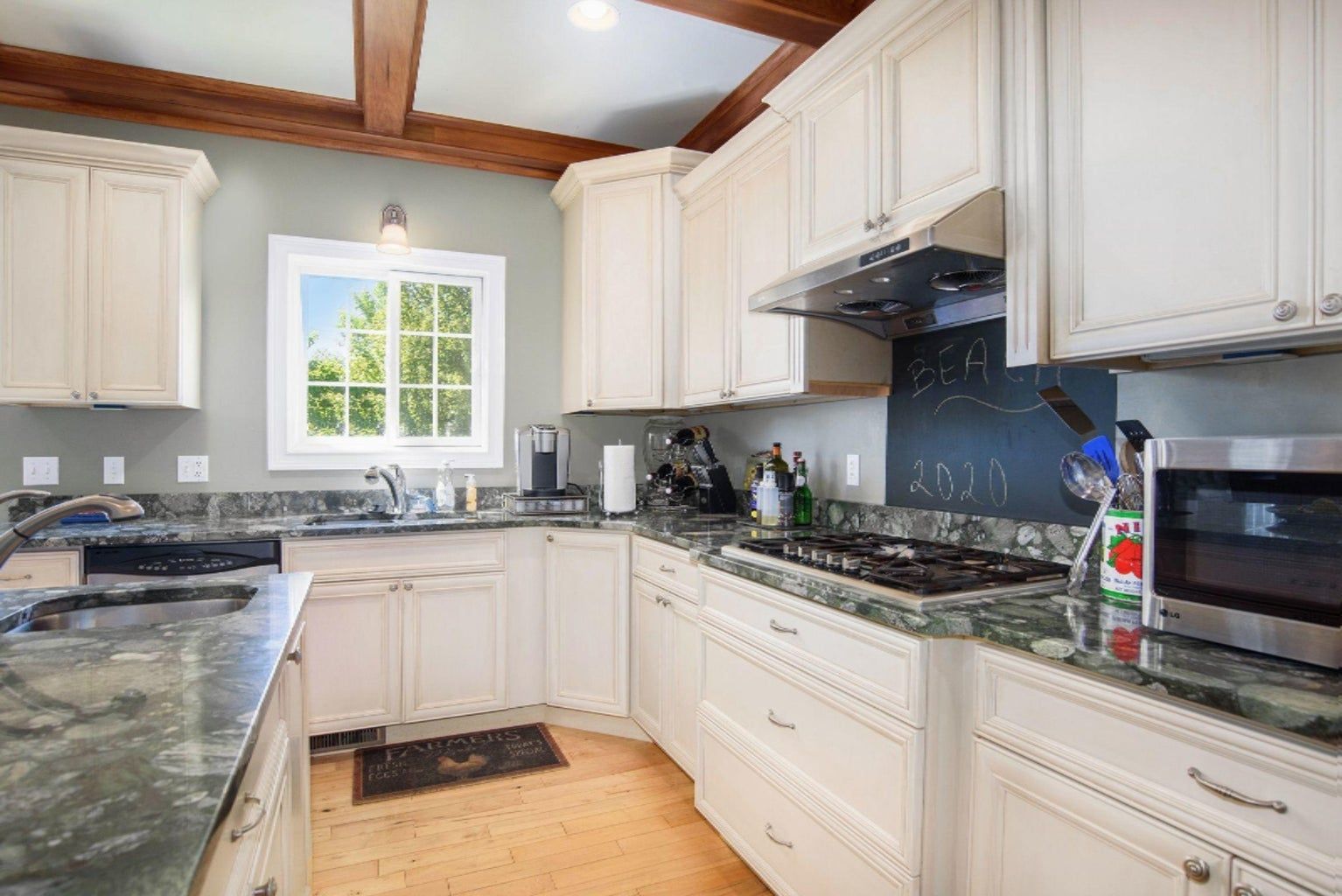 A kitchen with white cabinets and granite counter tops.