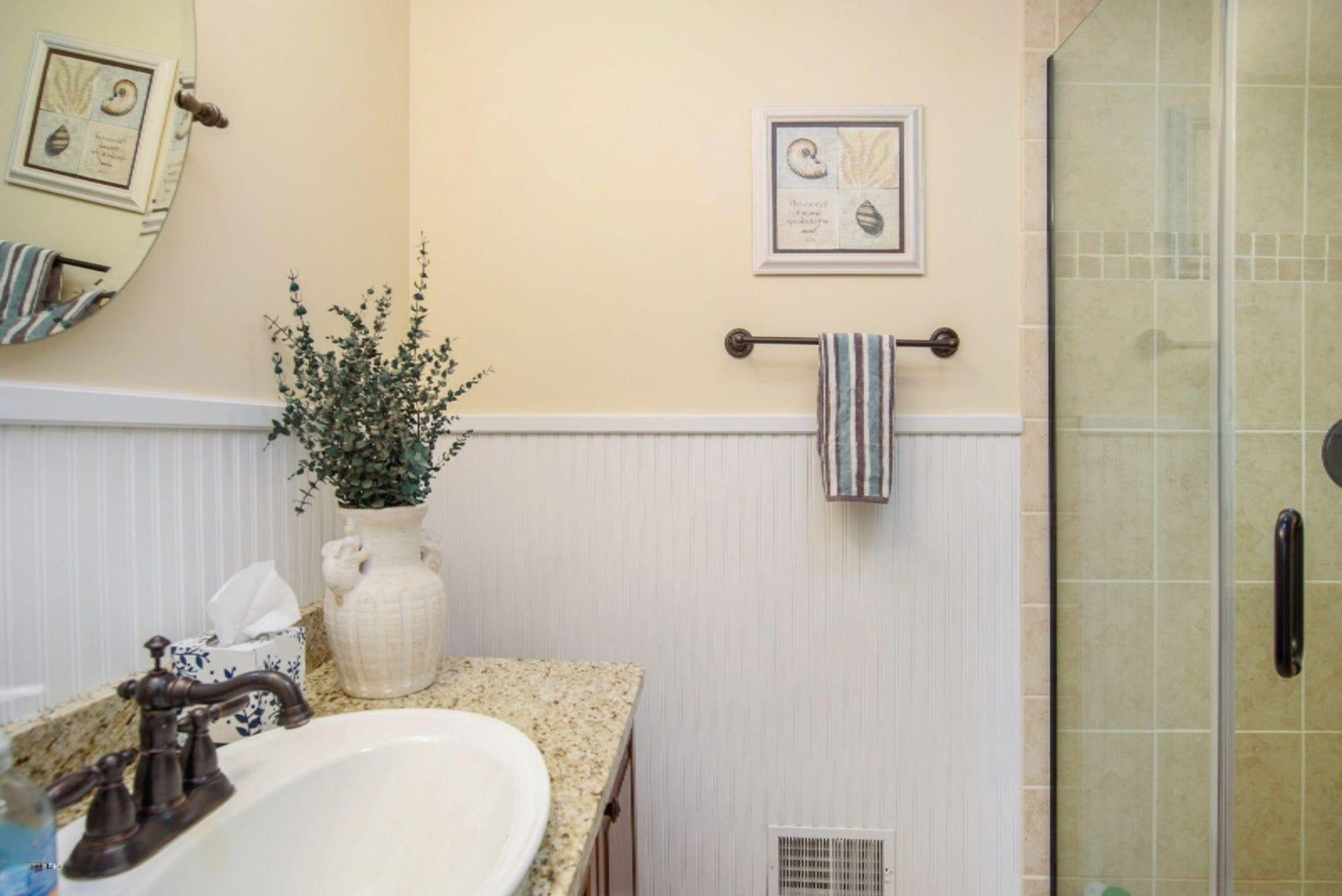 A bathroom with a sink , mirror , and shower.