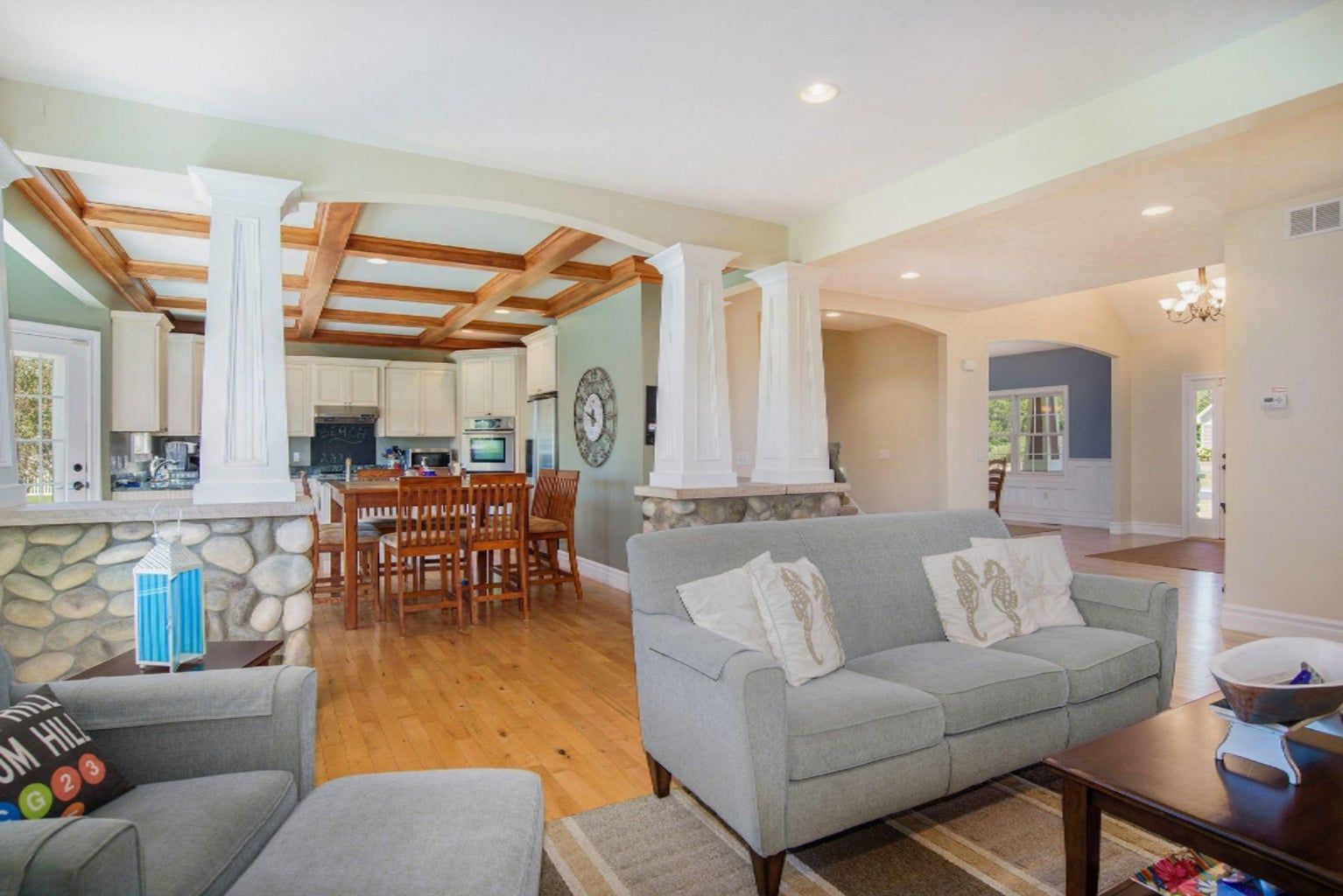 A living room with a couch , chair , coffee table and kitchen.
