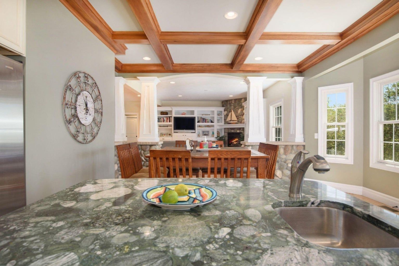 A kitchen with a sink and a clock on the wall.