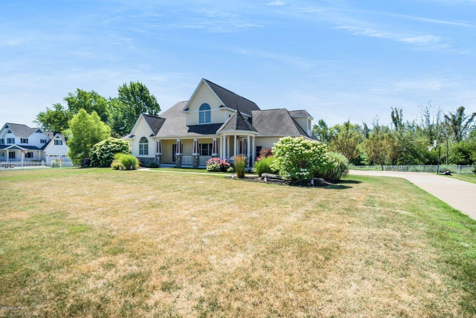 A large white house with a large lawn in front of it.