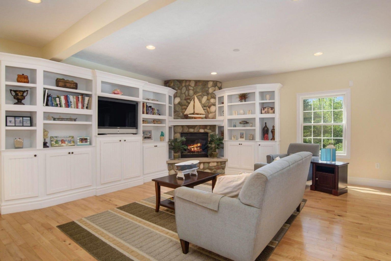 A living room with a fireplace , couch , table and television.
