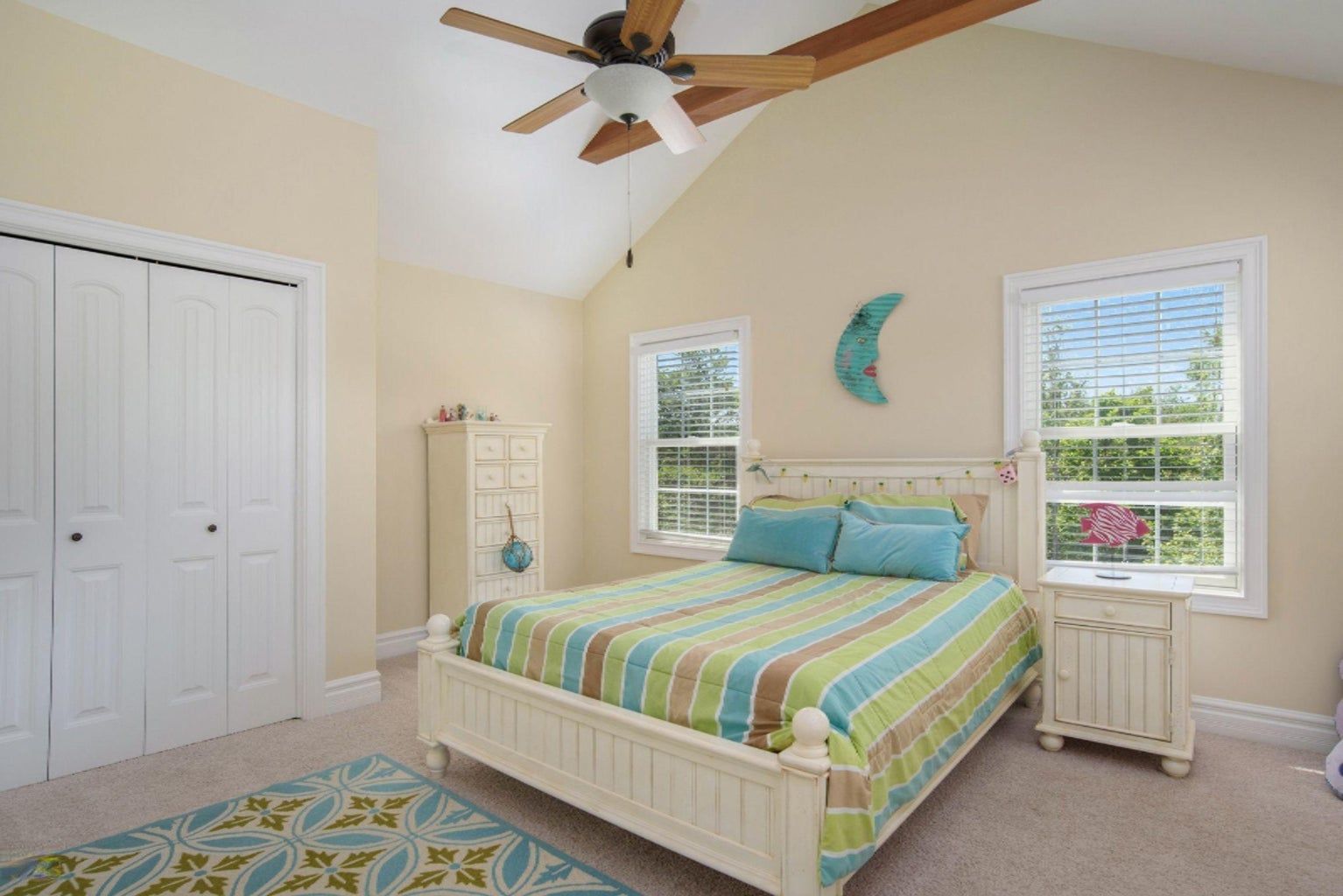 A bedroom with a bed and a ceiling fan