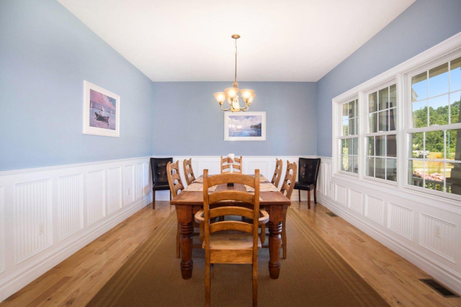 A dining room with a table and chairs and a chandelier