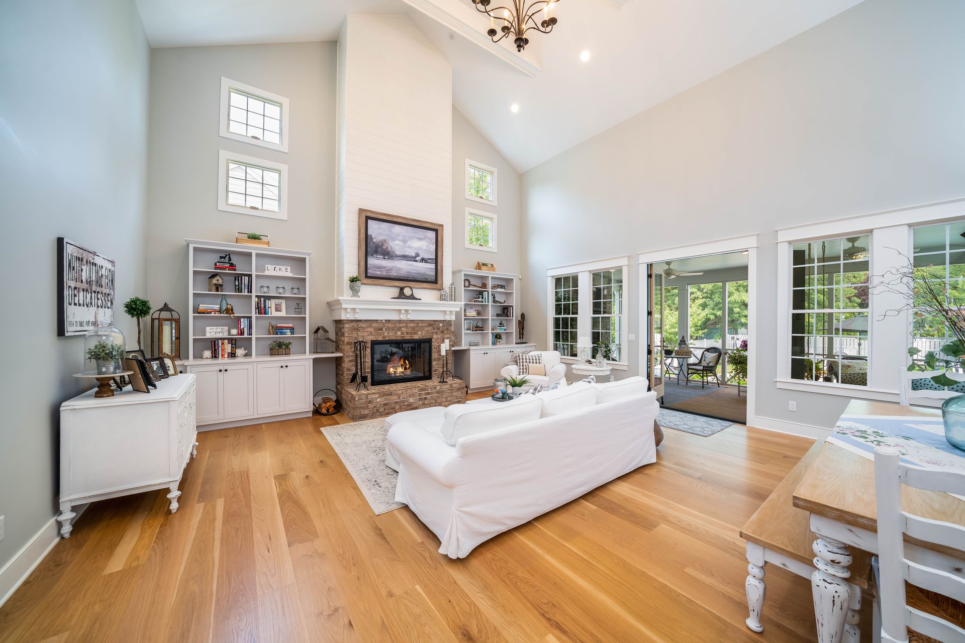 A living room with hardwood floors , a fireplace , a couch and a television.