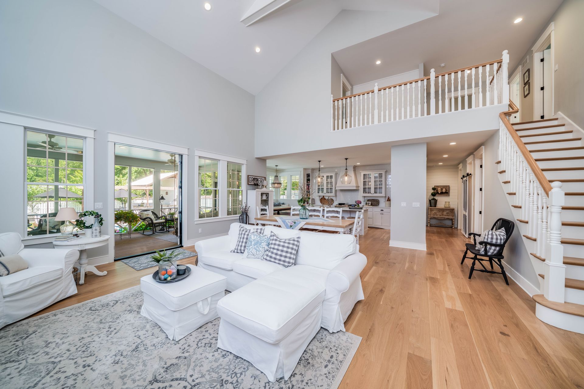 A living room filled with furniture and stairs leading up to the second floor.