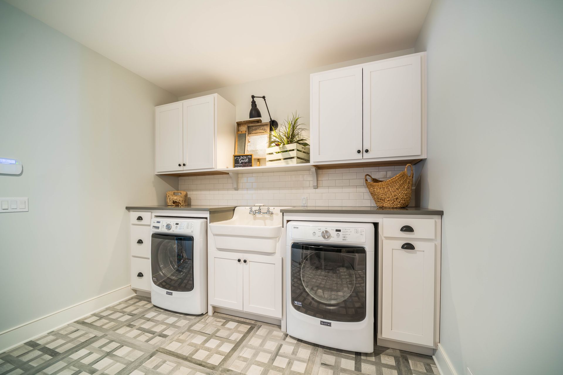 A laundry room with a washer and dryer , sink , and cabinets.