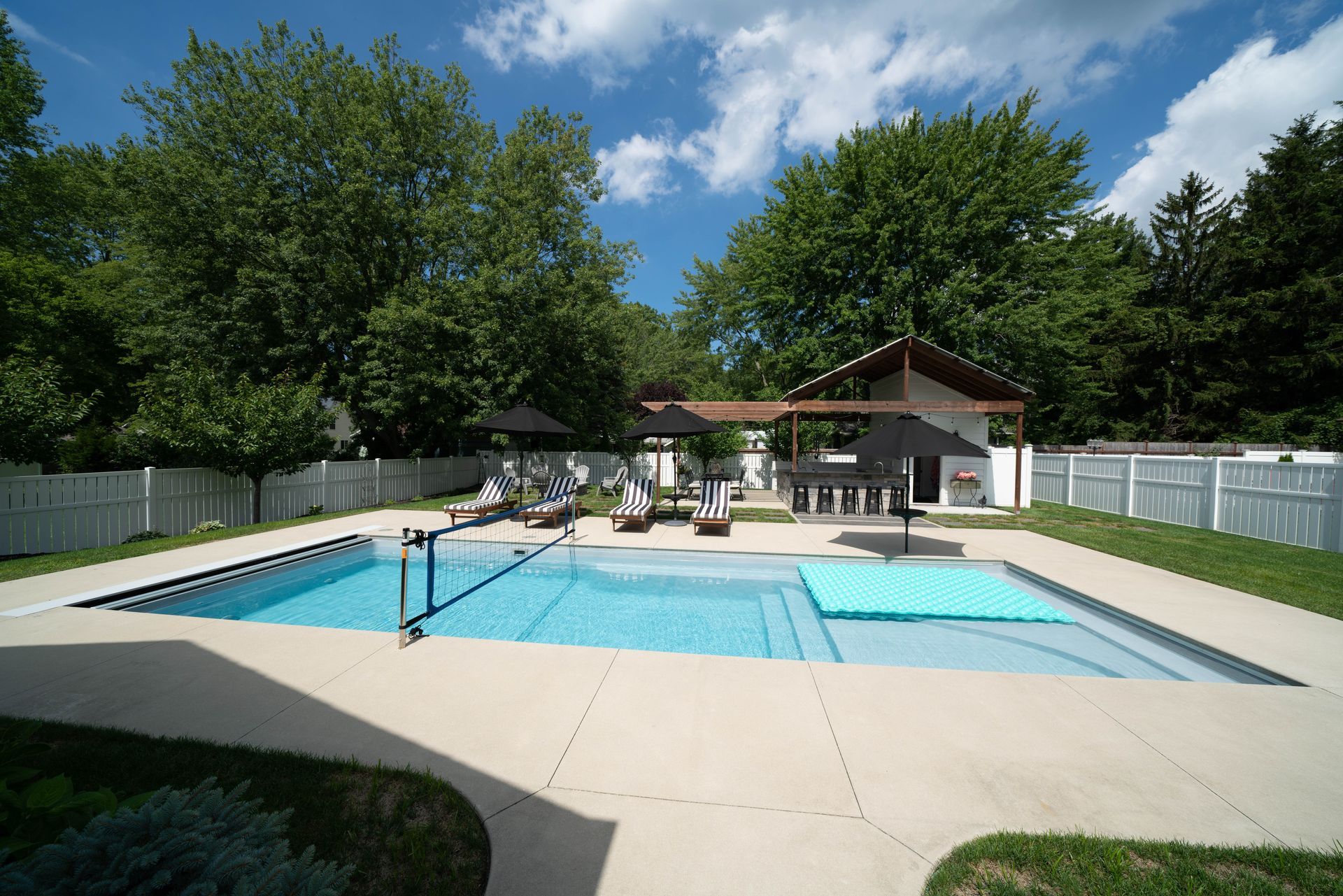 A large swimming pool in the backyard of a house