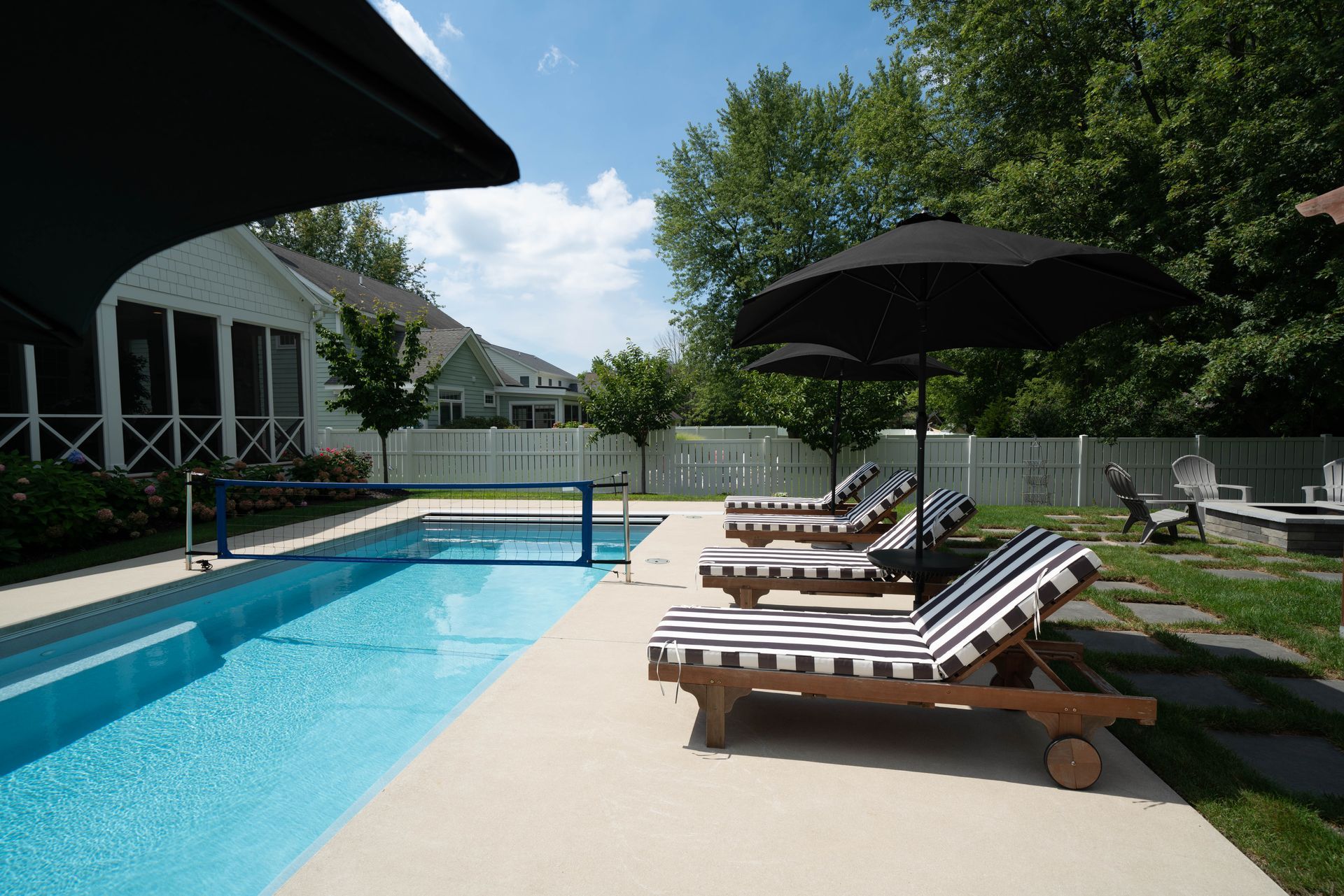 A swimming pool with chairs and umbrellas around it