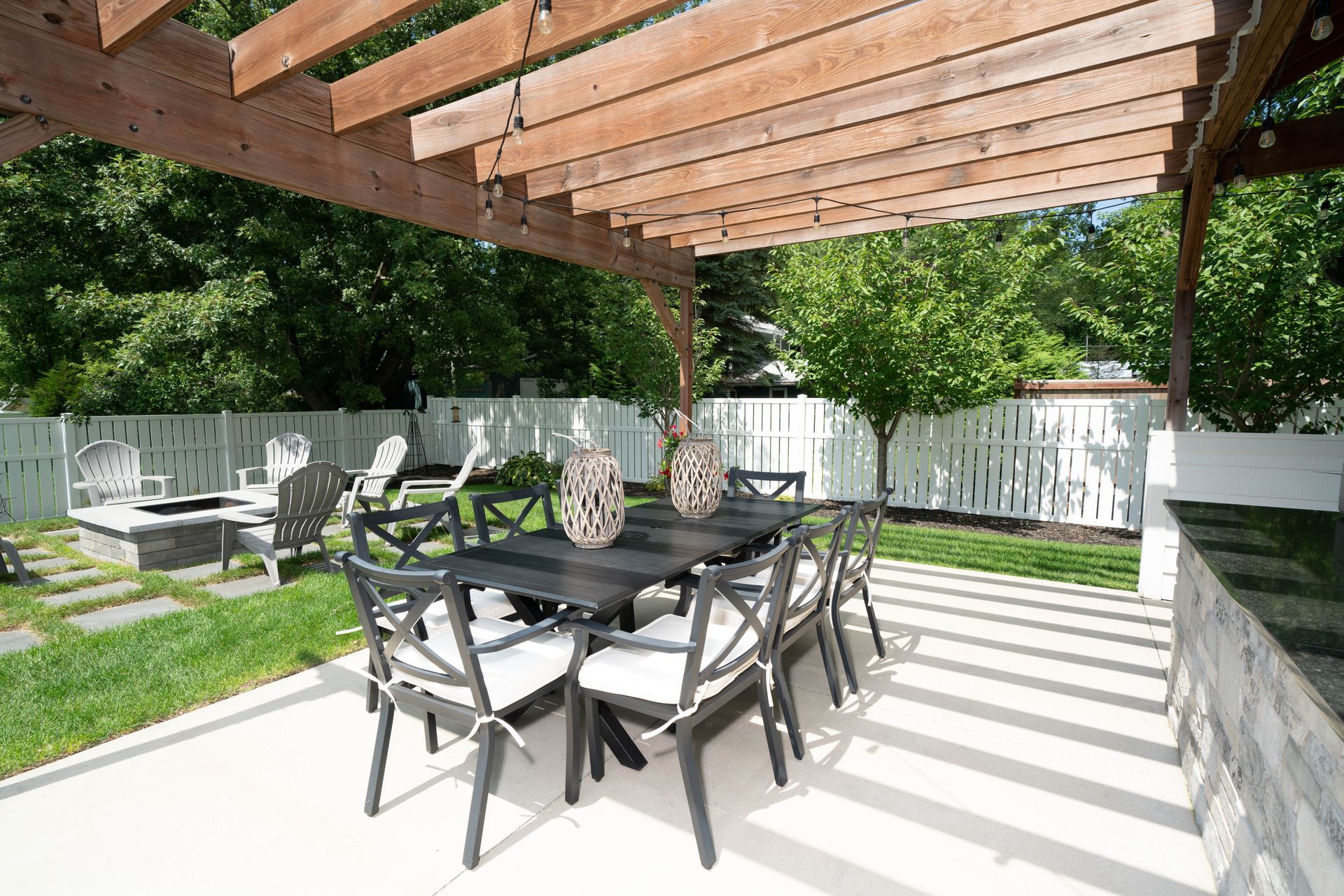 A patio with a table and chairs under a pergola.