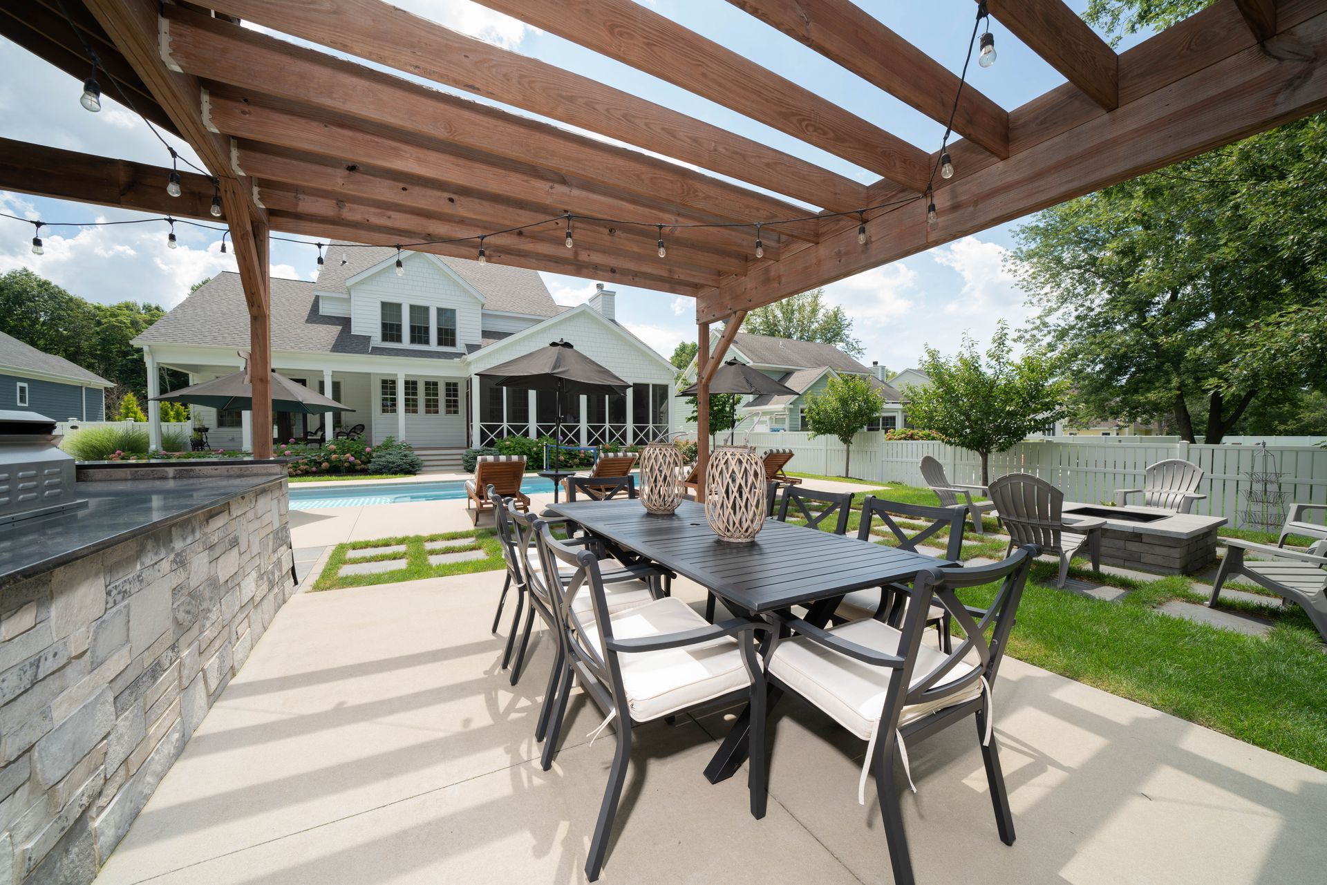A patio with a table and chairs under a pergola.