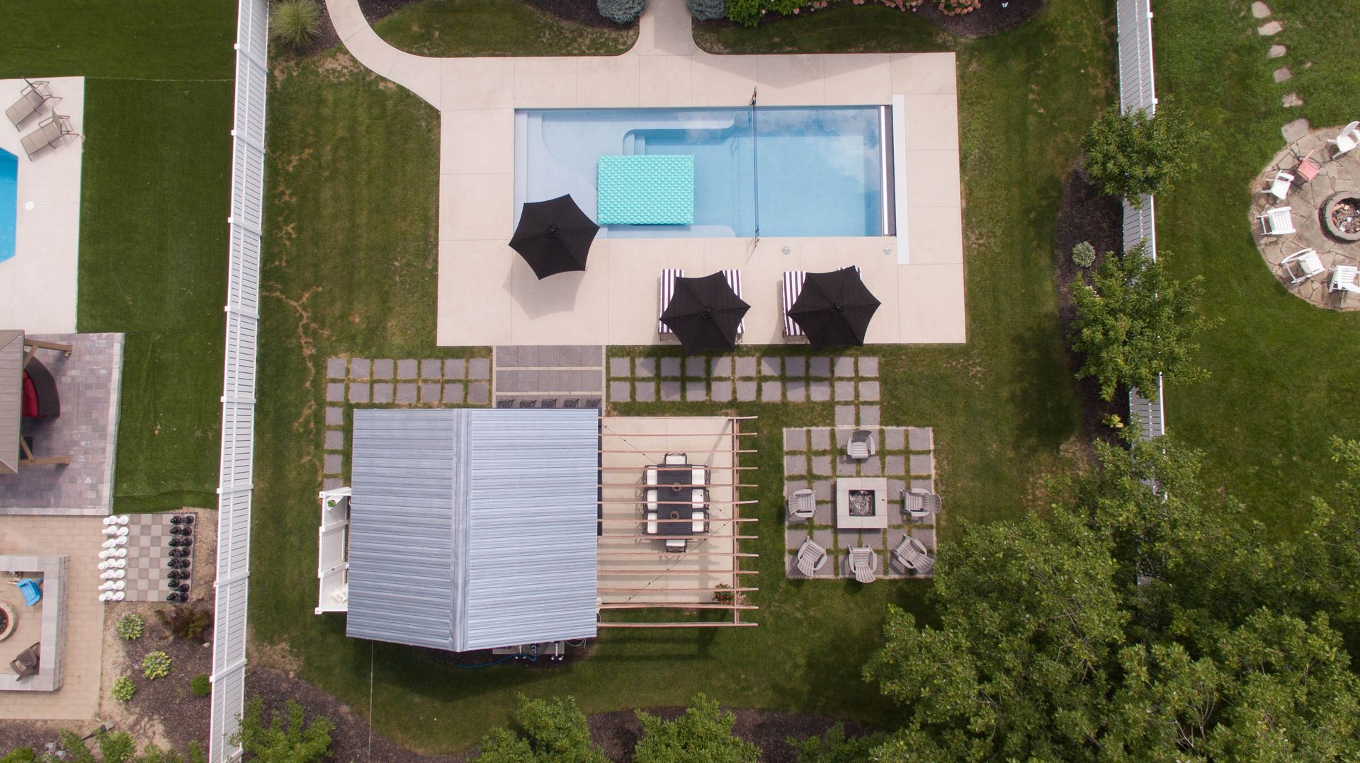 An aerial view of a house with a pool and umbrellas.