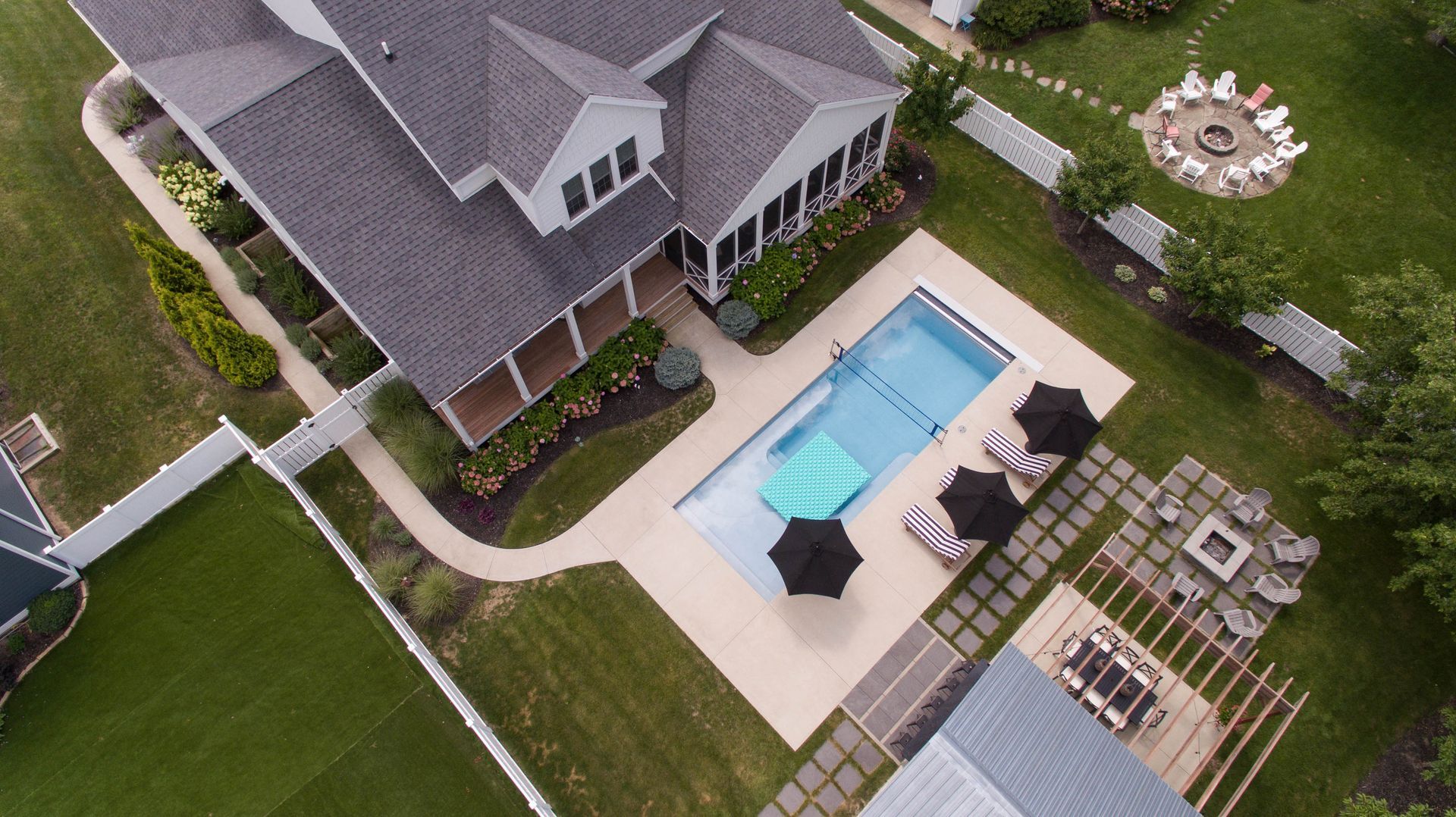 An aerial view of a house with a swimming pool and umbrellas.