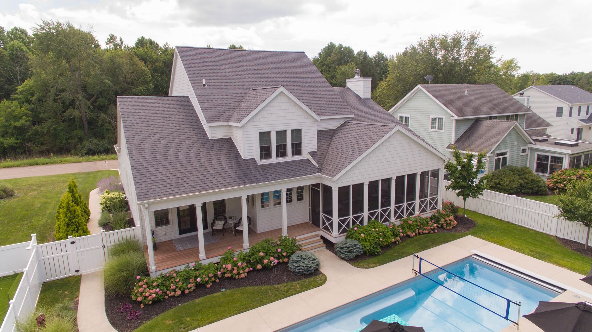 An aerial view of a large house with a swimming pool in the backyard.