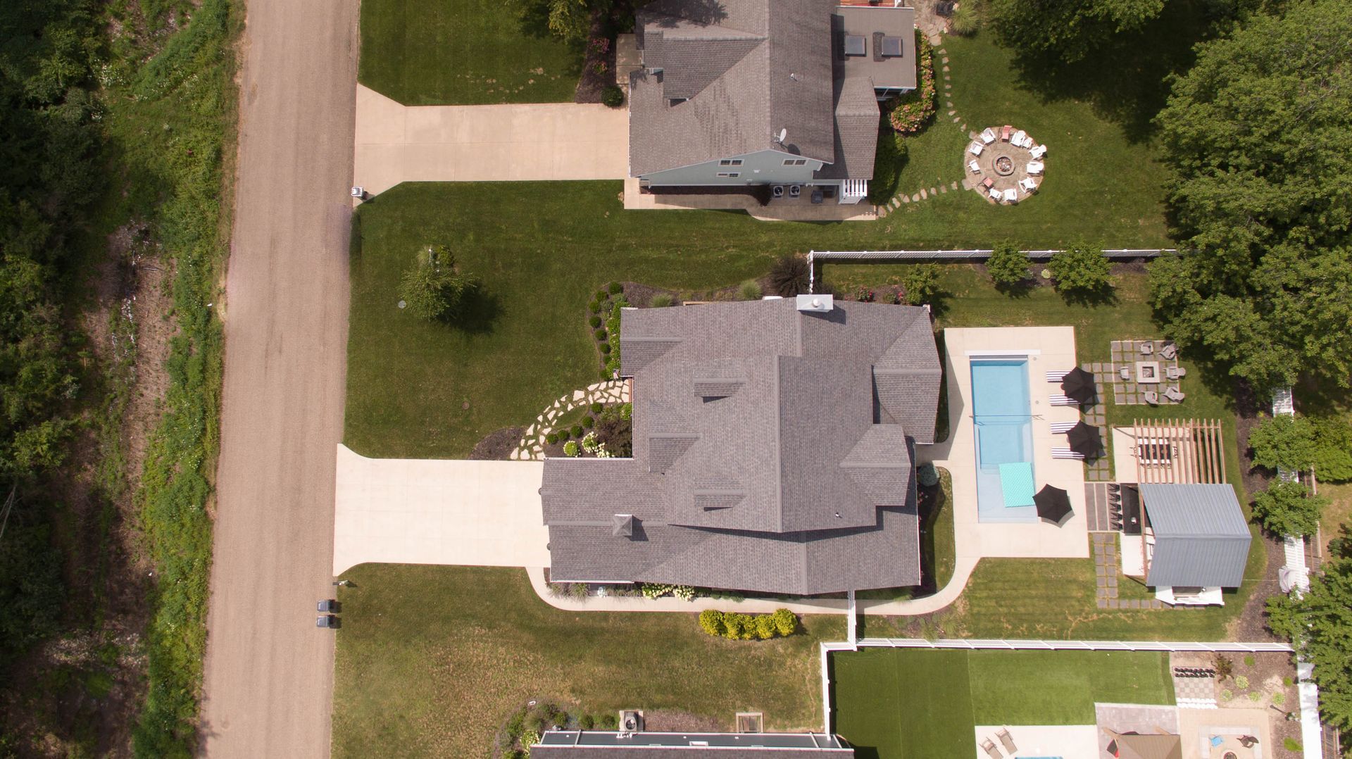 An aerial view of a house with a pool in the backyard.