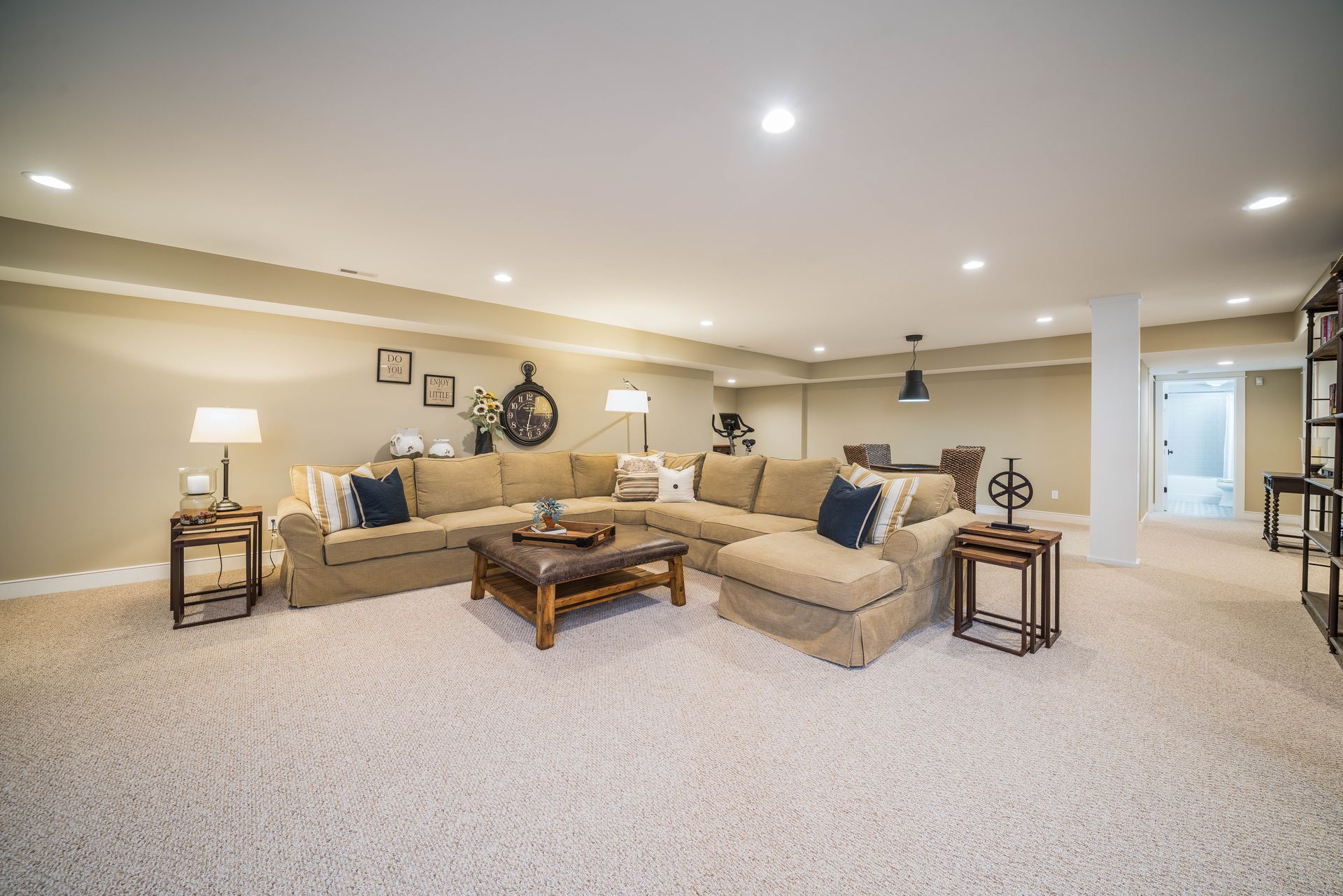 A living room in a basement with a large sectional couch and a coffee table.