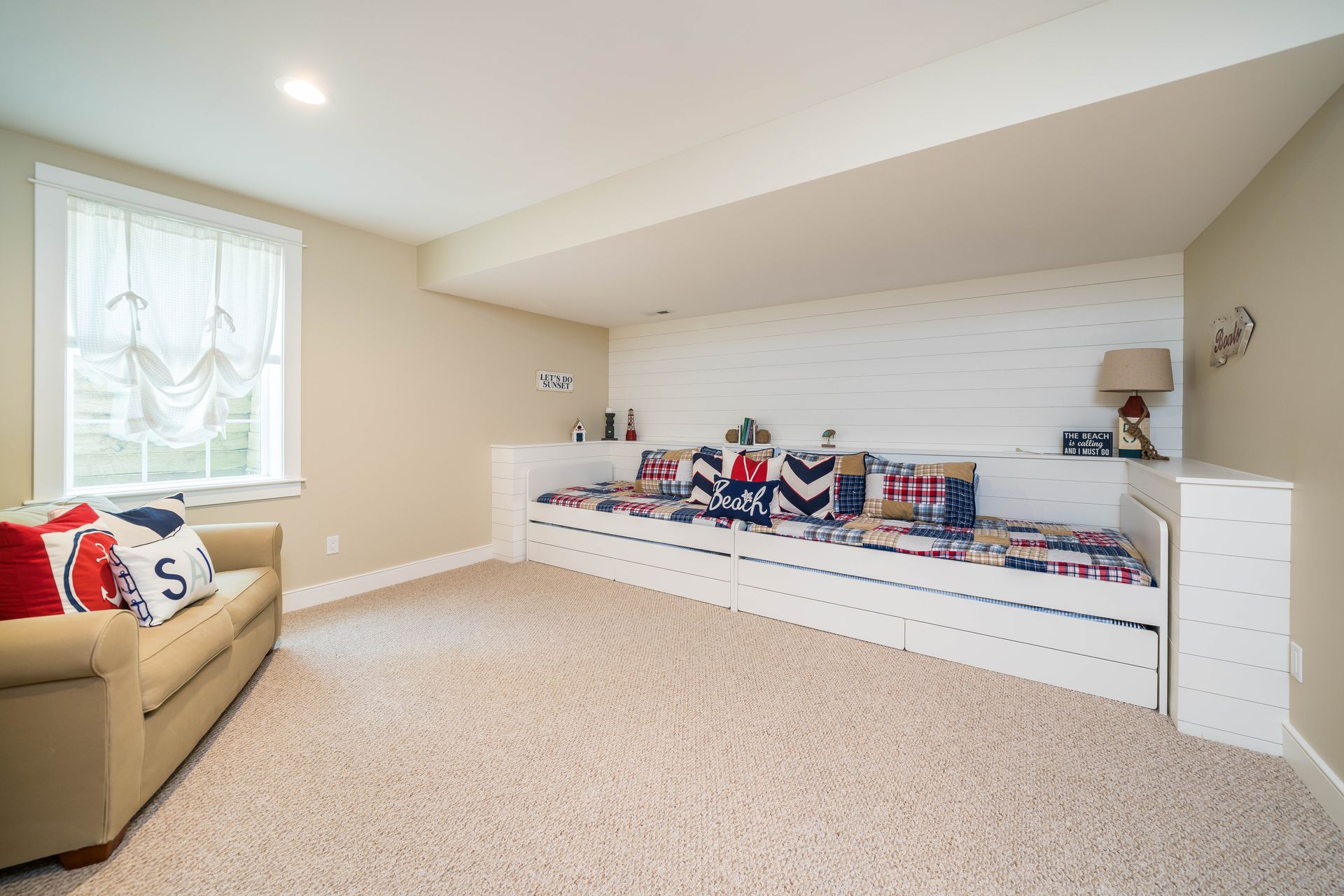 A living room with a couch and a bed in the corner.