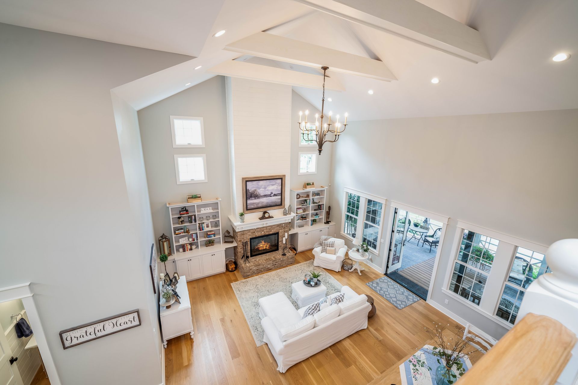 An aerial view of a living room with a couch , fireplace and television.