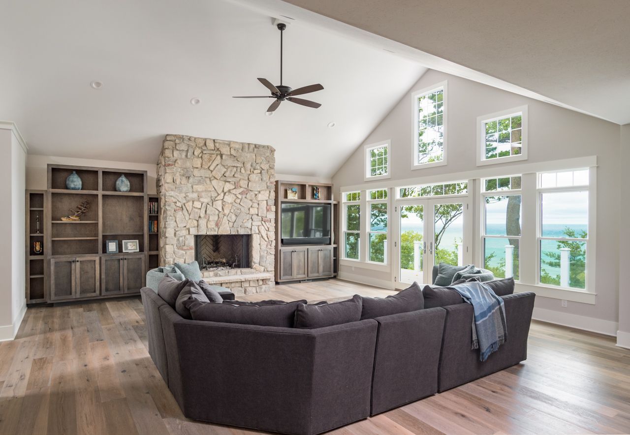 A living room with a couch , fireplace , and ceiling fan.