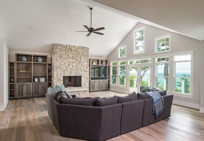A living room with a couch , fireplace , and ceiling fan.