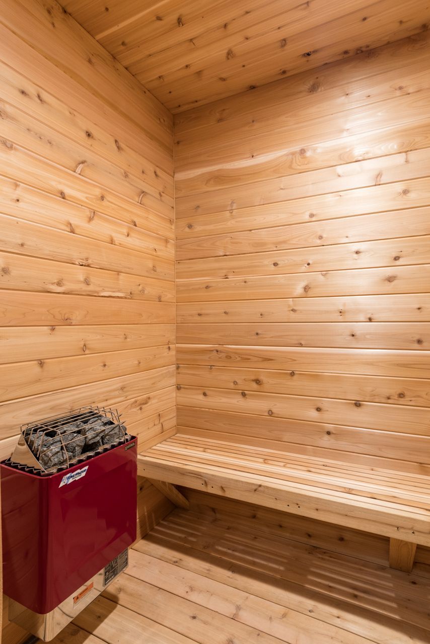 A wooden sauna with a bench and a heater.