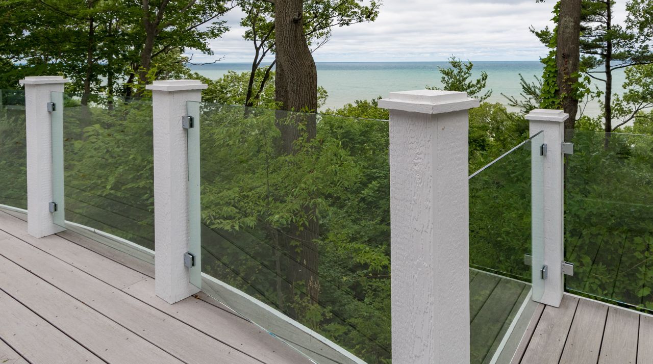 A deck with a glass railing and a view of the ocean