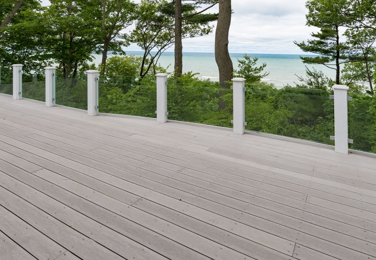 A deck with a view of the ocean and trees