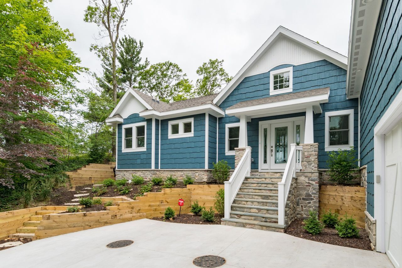 A blue and white house with stairs leading up to the front door.