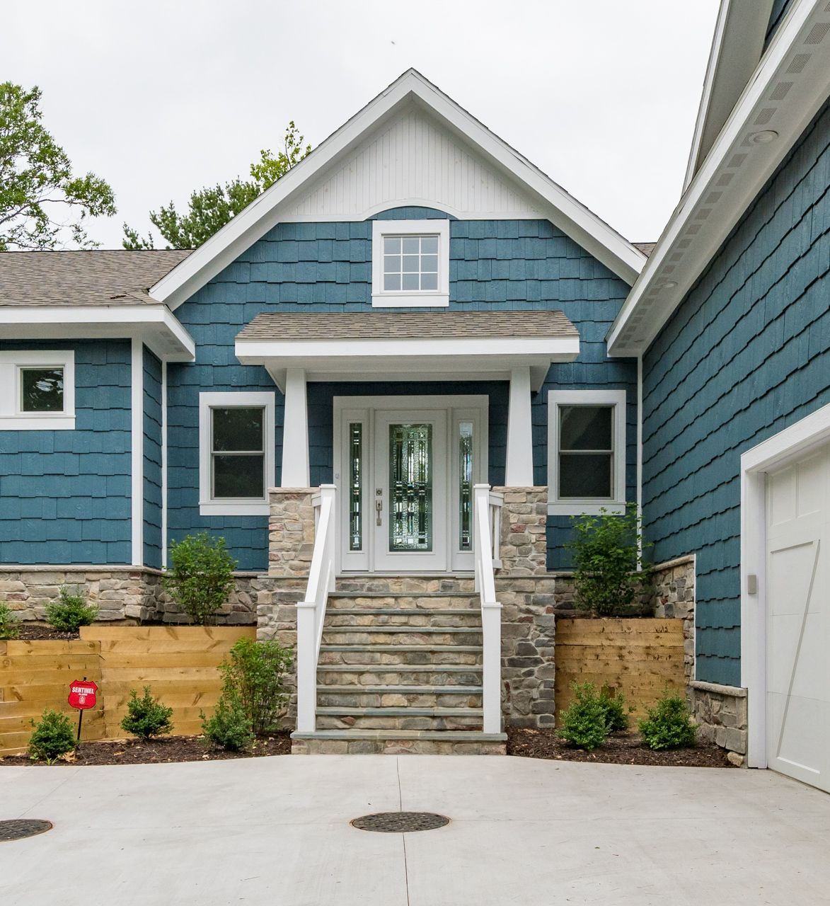 A blue house with white trim and stairs leading up to the front door