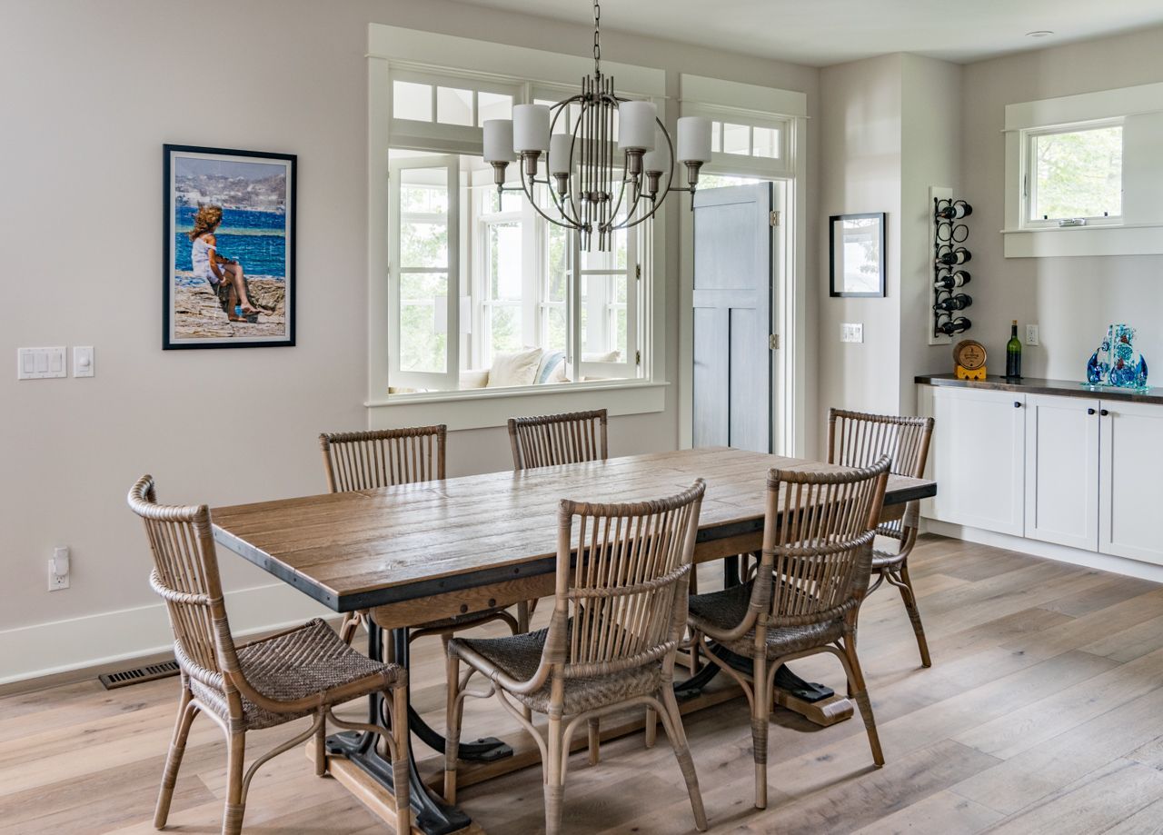 A dining room with a wooden table and chairs and a chandelier.