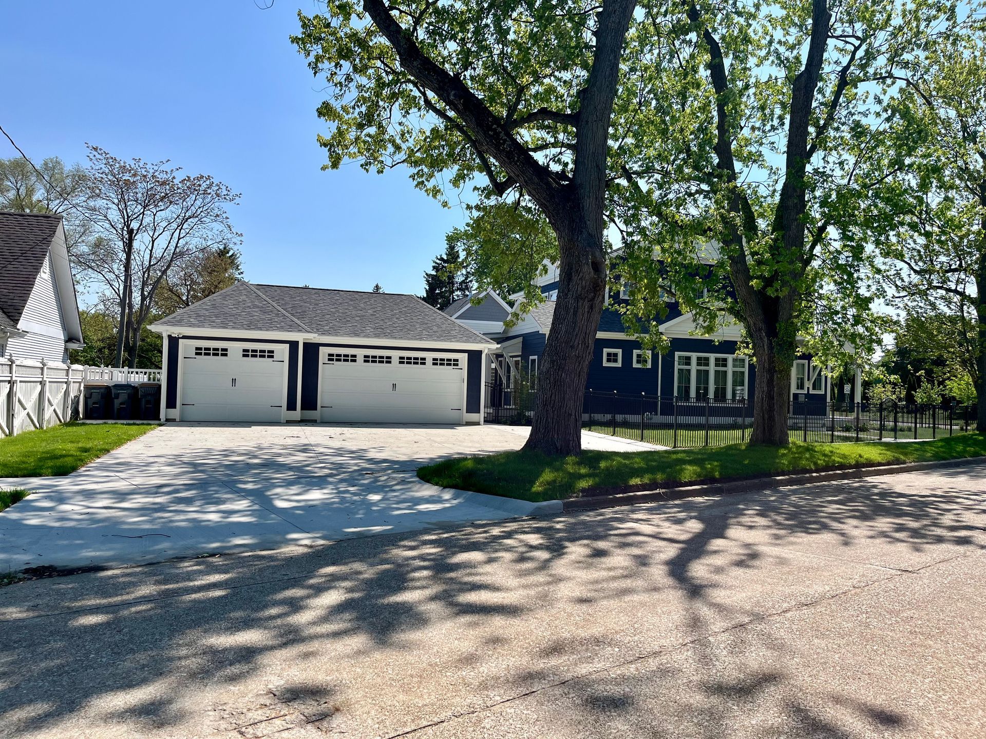 A house with two garages and a tree in front of it