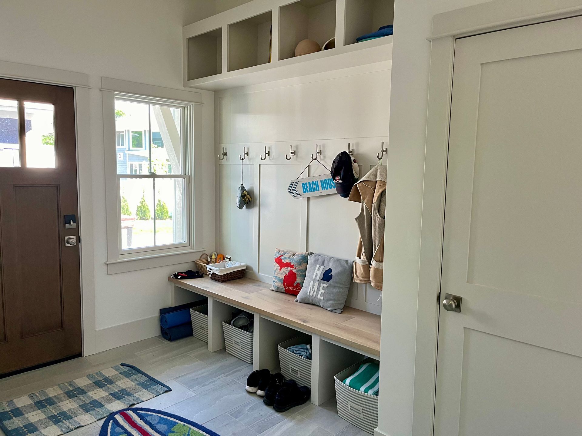 A mud room with a bench and hooks on the wall.