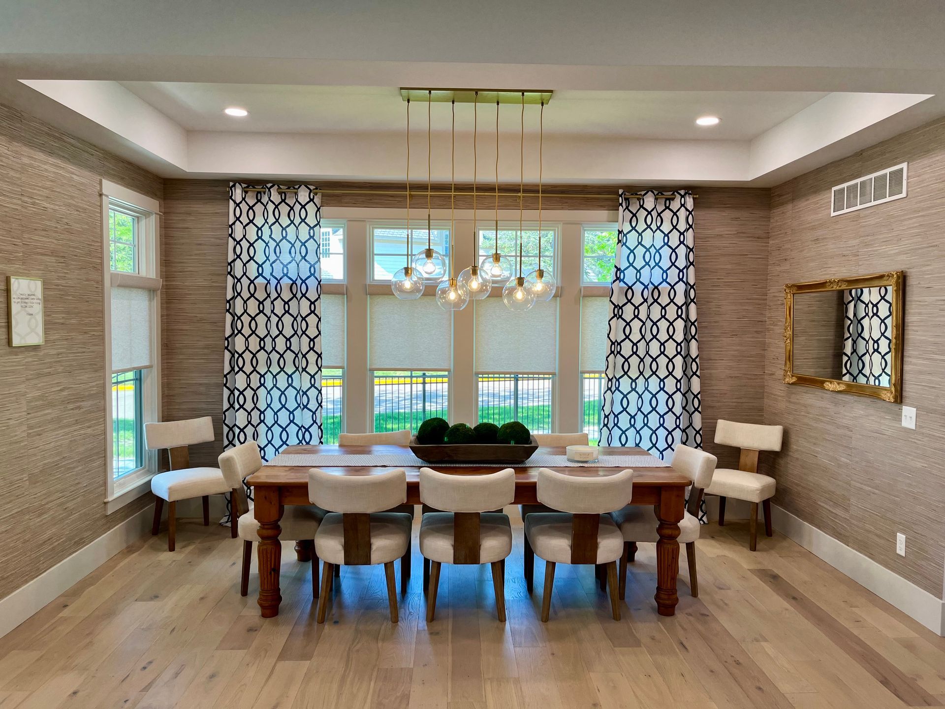 A dining room with a table and chairs and a chandelier hanging from the ceiling.