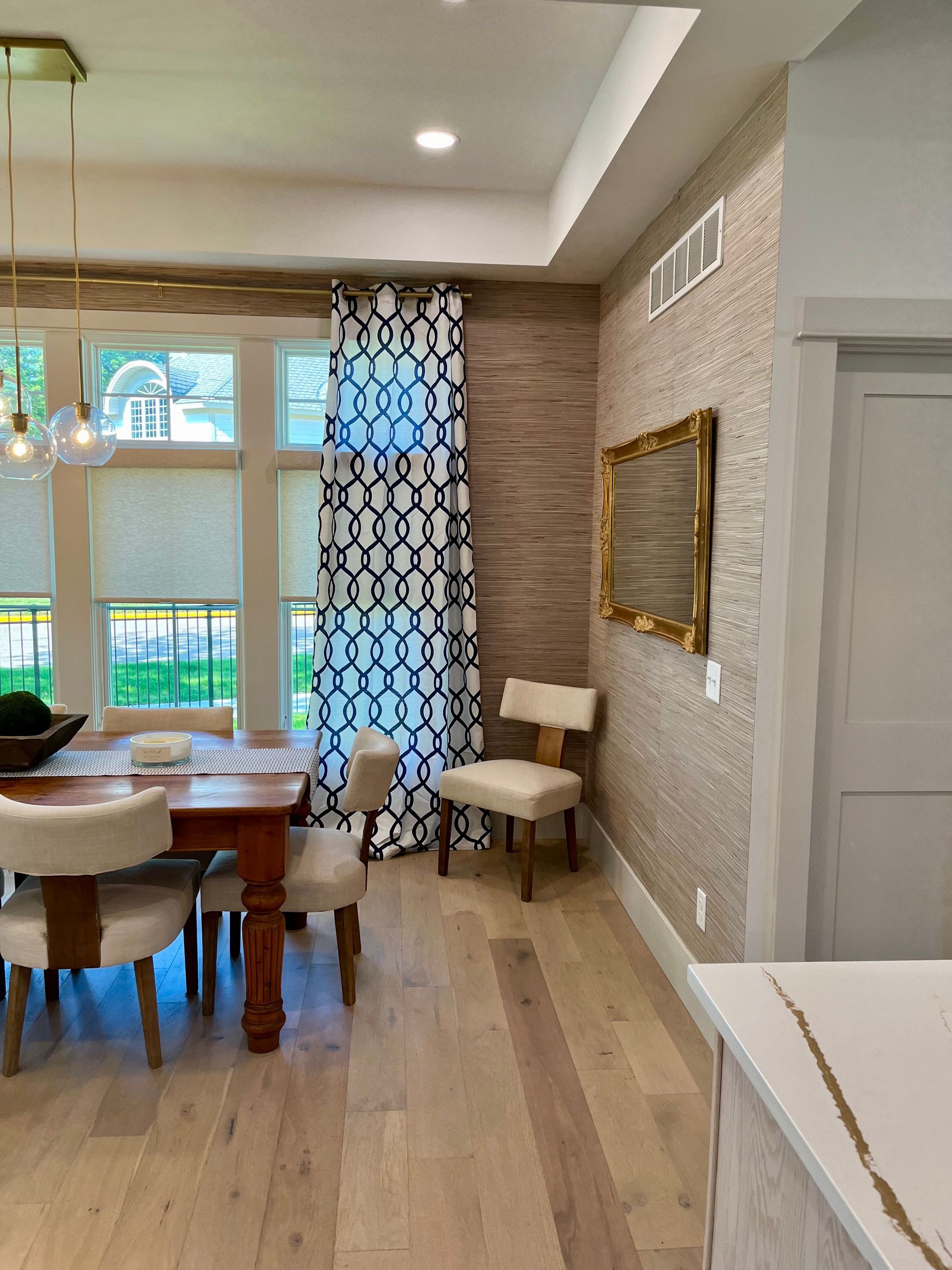 A dining room with a table and chairs and a mirror on the wall.