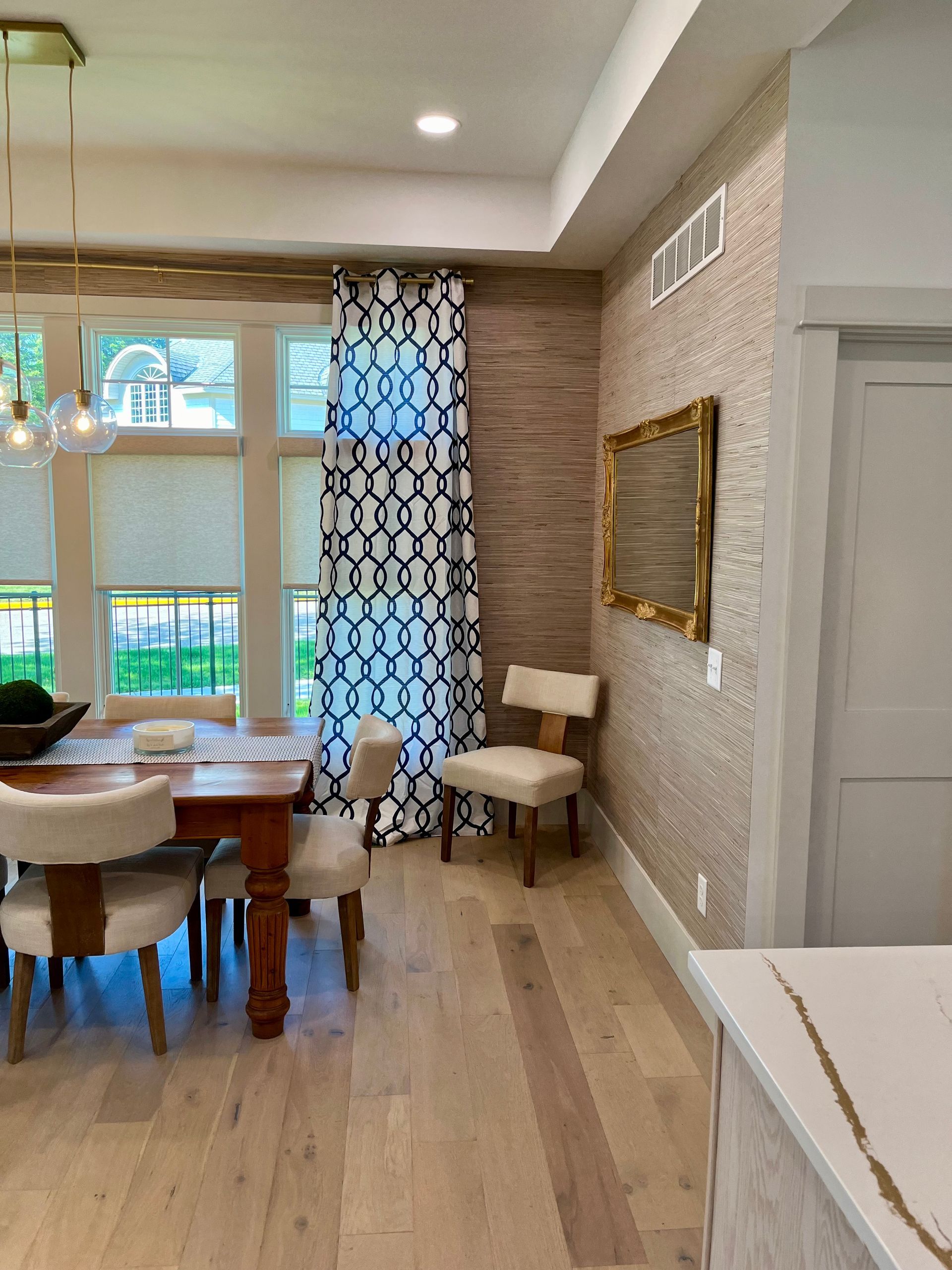A dining room with a table and chairs and a mirror on the wall.