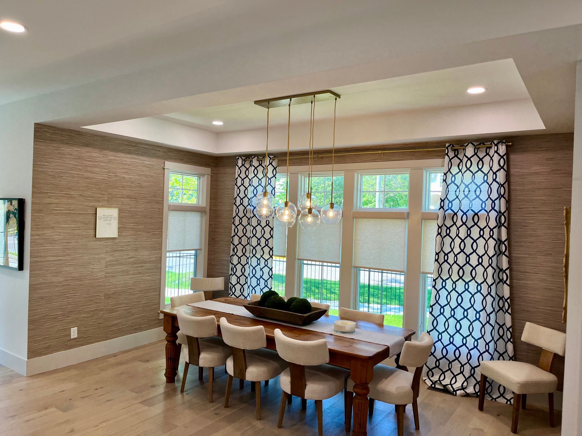 A dining room with a wooden table and chairs and a chandelier.