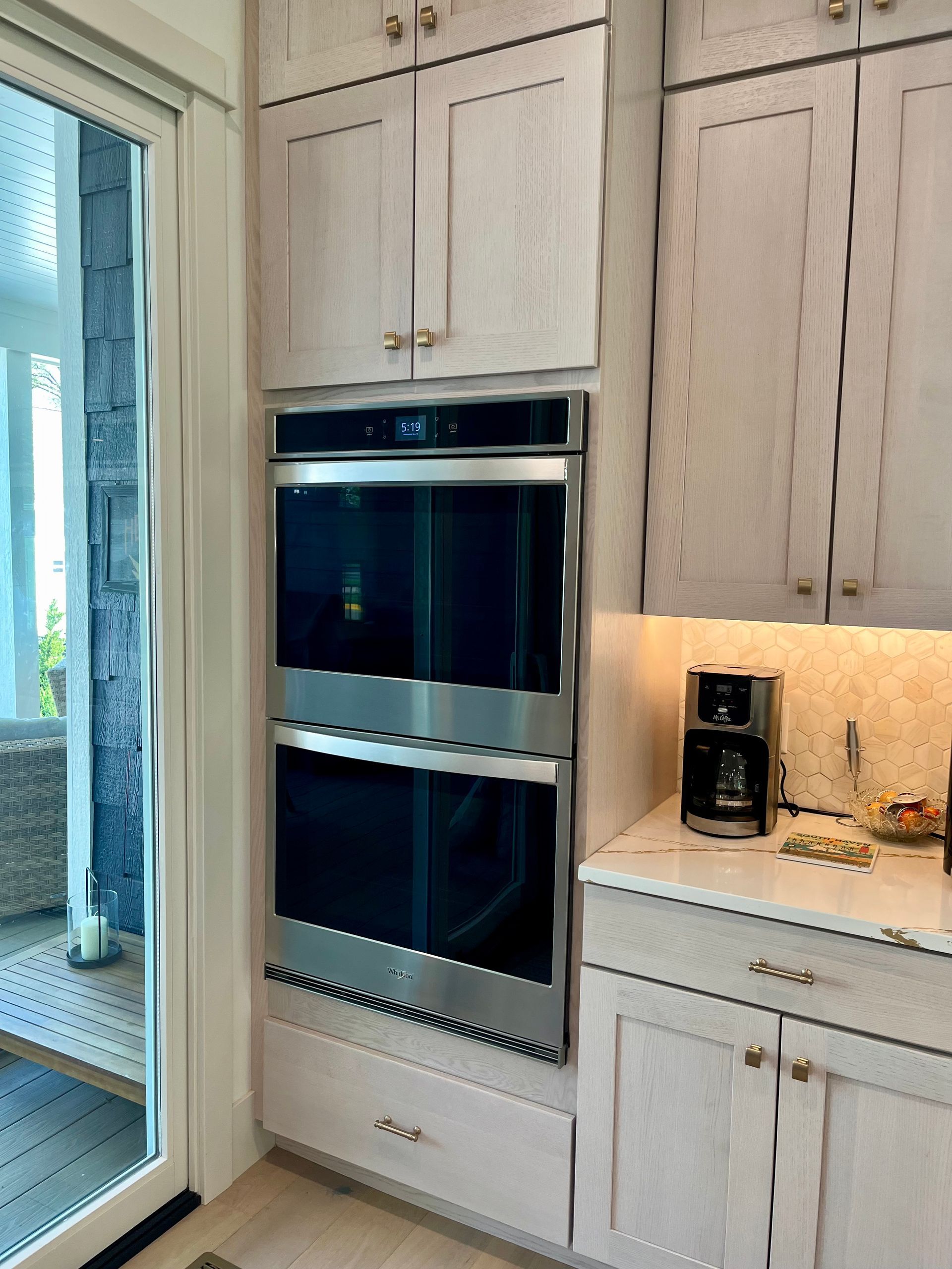 A kitchen with a double oven and a coffee maker