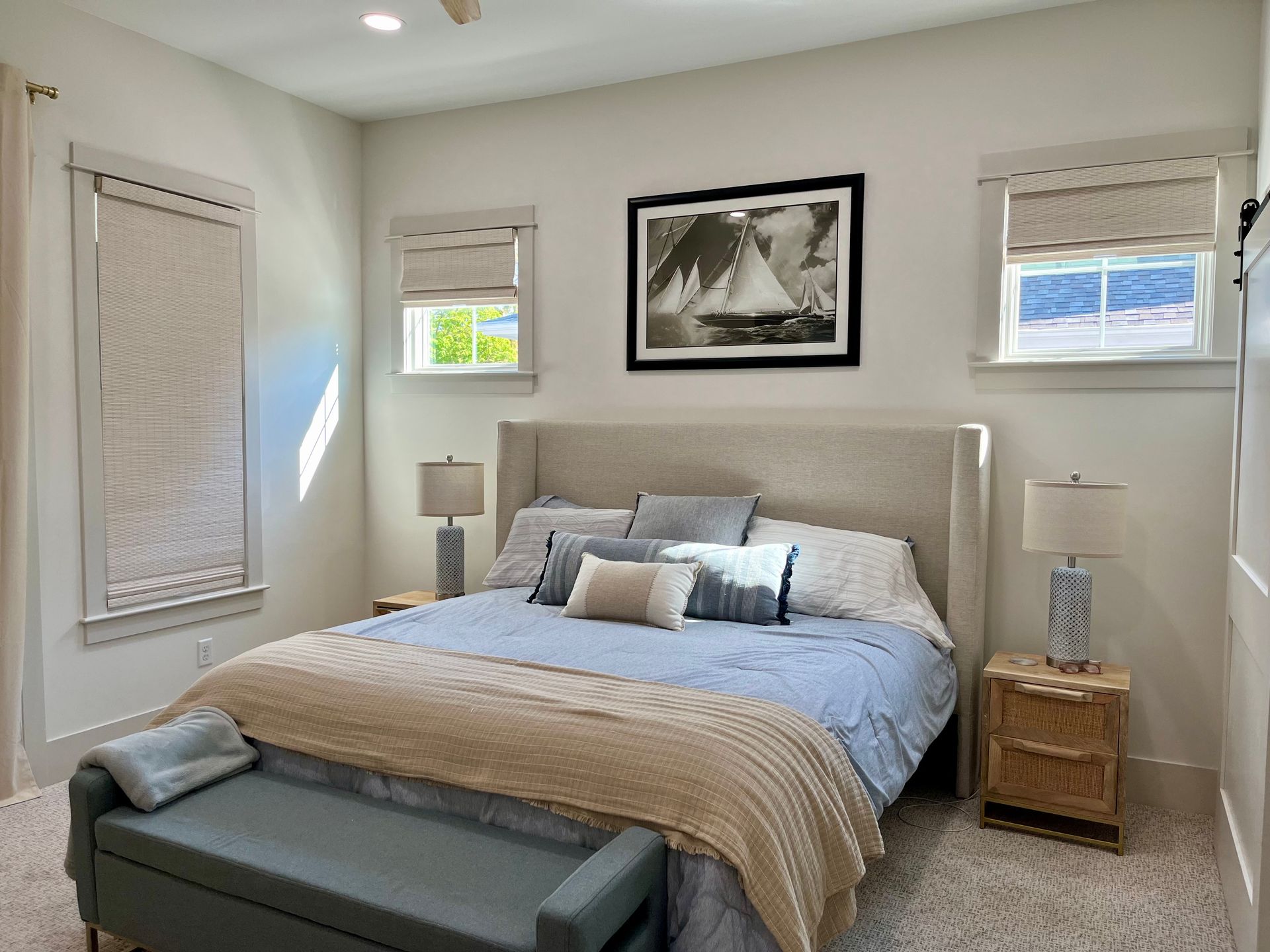 There is a picture of a sailboat on the wall above the bed in the bedroom.