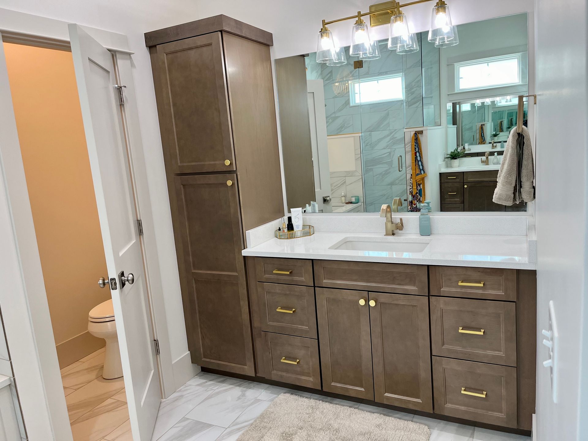 A bathroom with two sinks , a toilet , and a large mirror.
